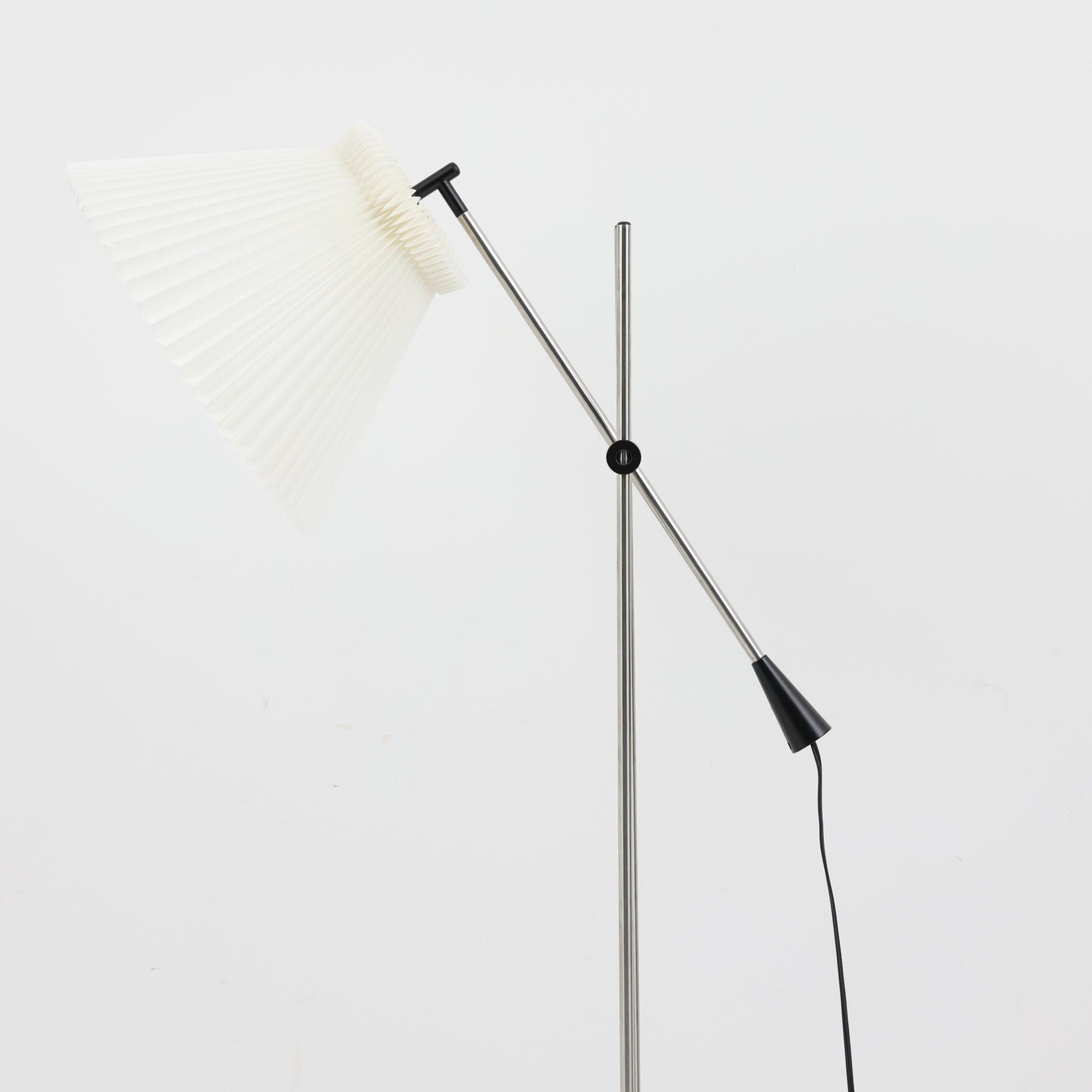 Christian Hvidtによってデザインされ、Le Klint社から発表されたフロアランプModel 323です。スチール製のシャープなフレームに、手作業で折り込まれたプリーツシェードを組み合わせた構成が特徴で、北欧デザインらしいシンプルかつ機能的な美しさを備えています。高さ135cmのバランスの良いサイズ感で、リビングや書斎に柔らかな光を届けます。角度調整可能なアームは使い勝手に優れ、読書灯や間接照明としても重宝するビンテージ品です。