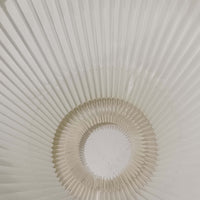 Erik Hansen（エリック・ハンセン）がデザインし、Le Klint（レ・クリント）から発表されたブラケットランプModel 332です。こちらは現行品には見られない一回り大きなサイズ感が特徴で、存在感のある佇まいを持っています。オーク材のナチュラルな風合いと、職人によるプリーツシェードが織りなす柔らかな光が空間を優しく包み込みます。アコーディオン式のアームは伸縮可能で、ベッドサイドやリビングの読書灯としても活躍する実用性の高い一品です。