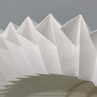 Erik Hansen（エリック・ハンセン）がデザインし、Le Klint（レ・クリント）から発表されたブラケットランプModel 332です。こちらは現行品には見られない一回り大きなサイズ感が特徴で、存在感のある佇まいを持っています。オーク材のナチュラルな風合いと、職人によるプリーツシェードが織りなす柔らかな光が空間を優しく包み込みます。アコーディオン式のアームは伸縮可能で、ベッドサイドやリビングの読書灯としても活躍する実用性の高い一品です。