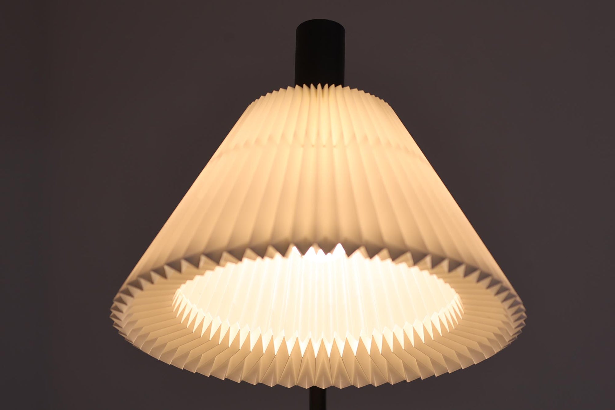 家具職人フレミング・アガー（Flemming Agger）によってデザインされた「372」は、金属の支柱にシェードを組み合わせたシンプルで洗練されたデザインが特徴です。プラスチック製のシェードは光を柔らかく拡散し、部屋全体に心地よい明るさを広げます。モダンなインテリアにぴったりなこの照明は、特にダイニングエリアやリビングルームでの使用に最適です。