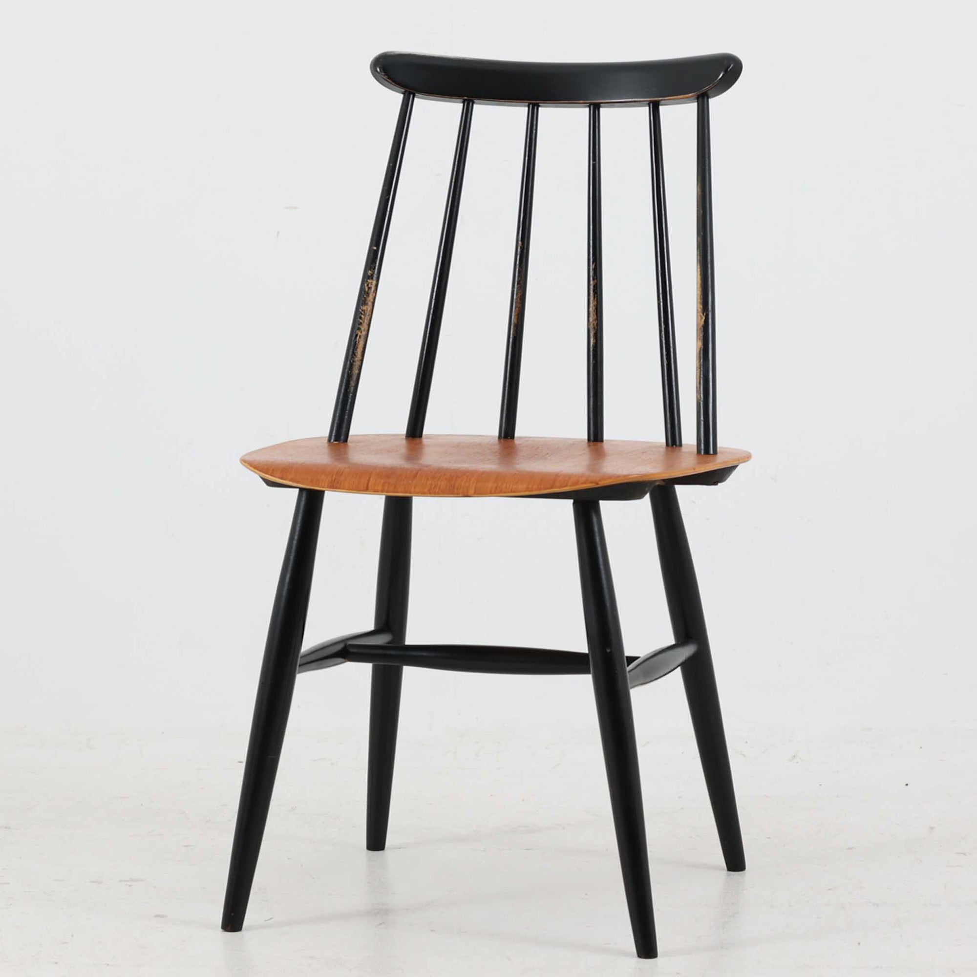 Ilmari Tapiovaara（イルマリ・タピオヴァーラ）がデザインし、スウェーデンのEDSBY VERKEN社から製造されたFannetチェアです。チーク材の座面とブラックペイントのフレームのコントラストが美しく、北欧らしいシンプルかつ温かみのある佇まいが魅力です。背もたれのスポークが軽やかな印象を与え、軽快ながらも安定感のある座り心地を実現しています。ダイニングやデスクチェアとしてはもちろん、単体で置いても存在感を放ち、経年による風合いがさらに味わいを深める一脚です。