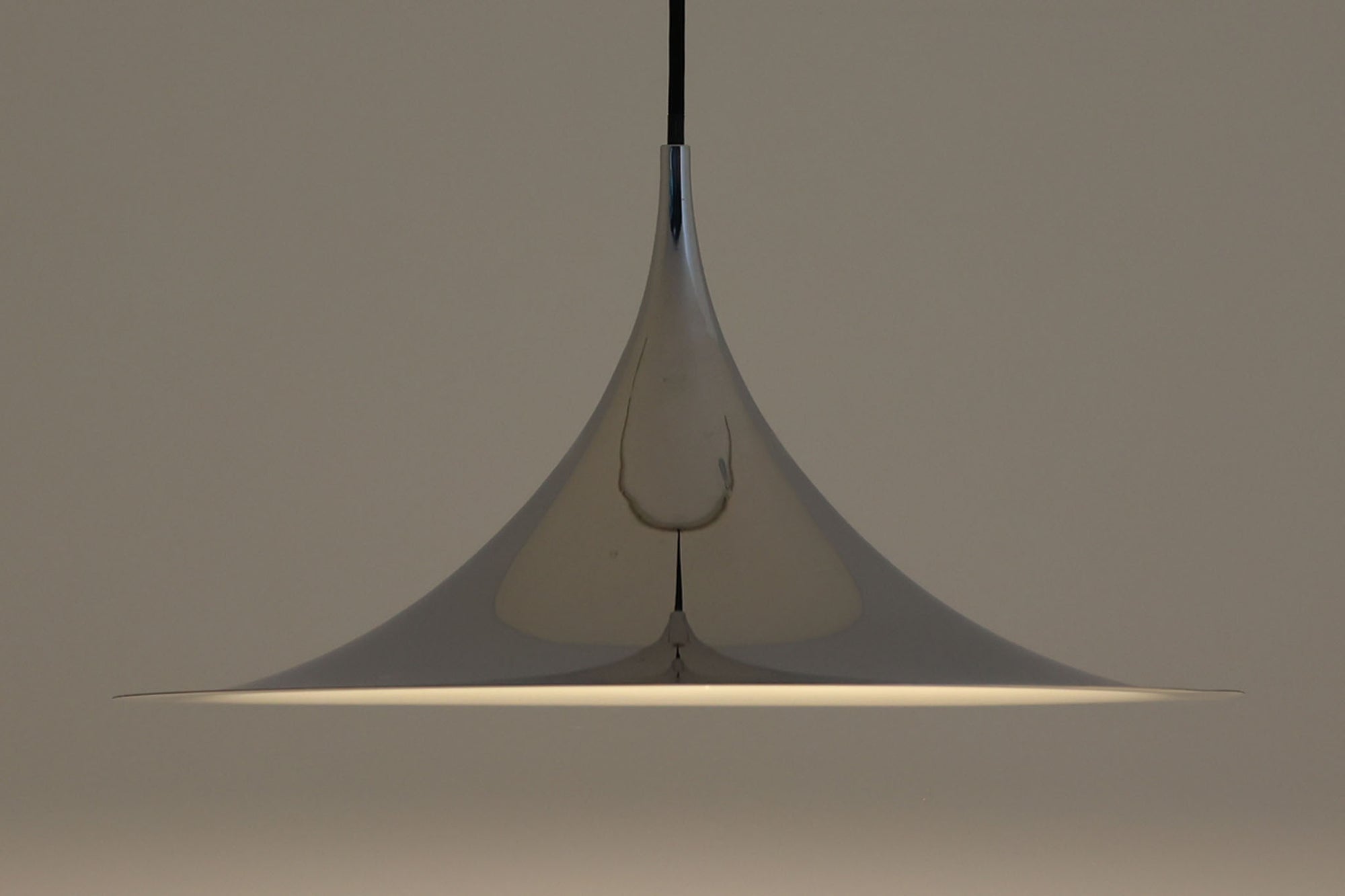 1967年にClaus Bonderup & Torsten Thorupによってデザインされた名作「Semiペンダントランプ」です。高度な技術で一枚のアルミ板を絞り出すことで、美しいラインが形成されています。ビンテージ品のクロームは現地でも中々見かけない希少なモデルとなります。