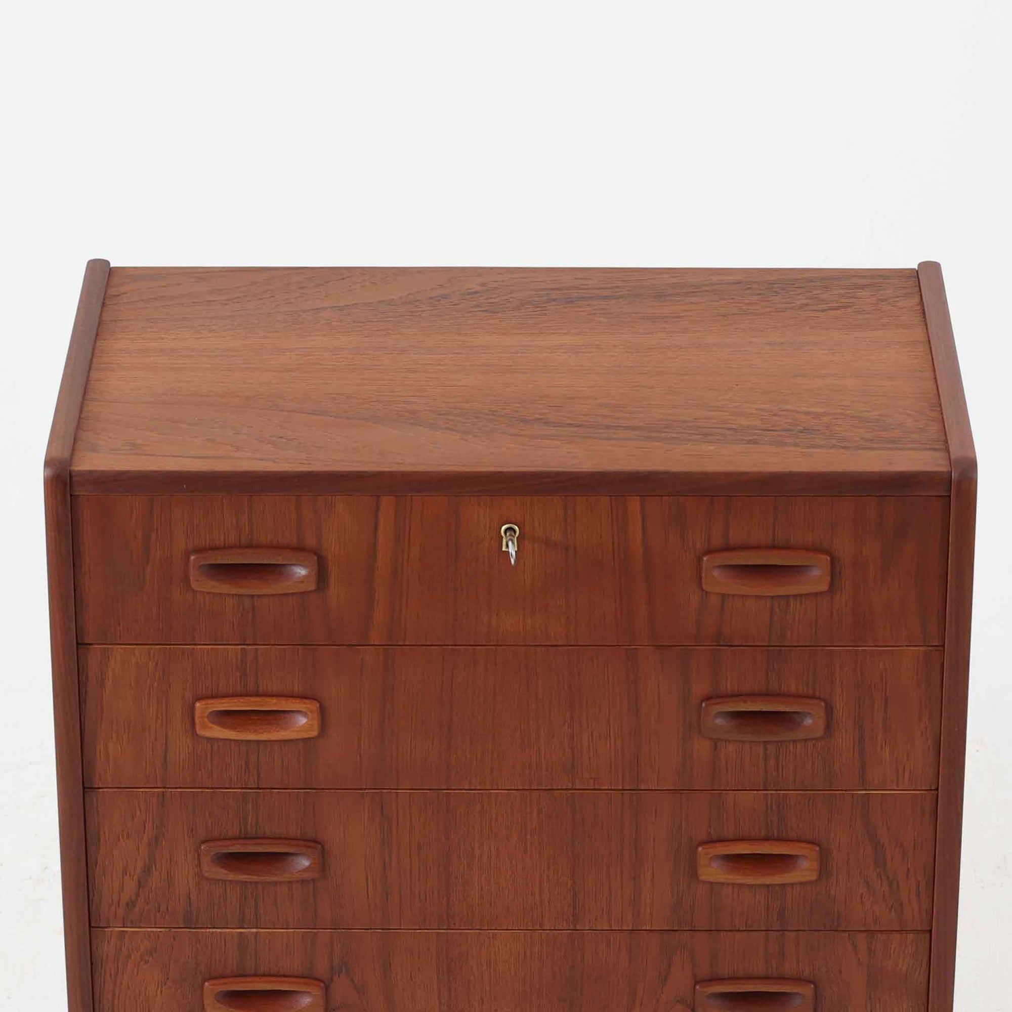 北欧ビンテージらしい温もりを感じさせるこちらの4段チェストは、上質なチーク材を使用したデンマーク製の一台です。無垢材を削り出したような立体感のある取手がアクセントとなっており、シンプルながらも丁寧な造りが際立ちます。幅70cmと程よいサイズ感で、寝室やリビングの収納としてはもちろん、玄関先の小物整理にも活躍します。使い込むほどに深まる色艶や木目の味わいも魅力のひとつです。
