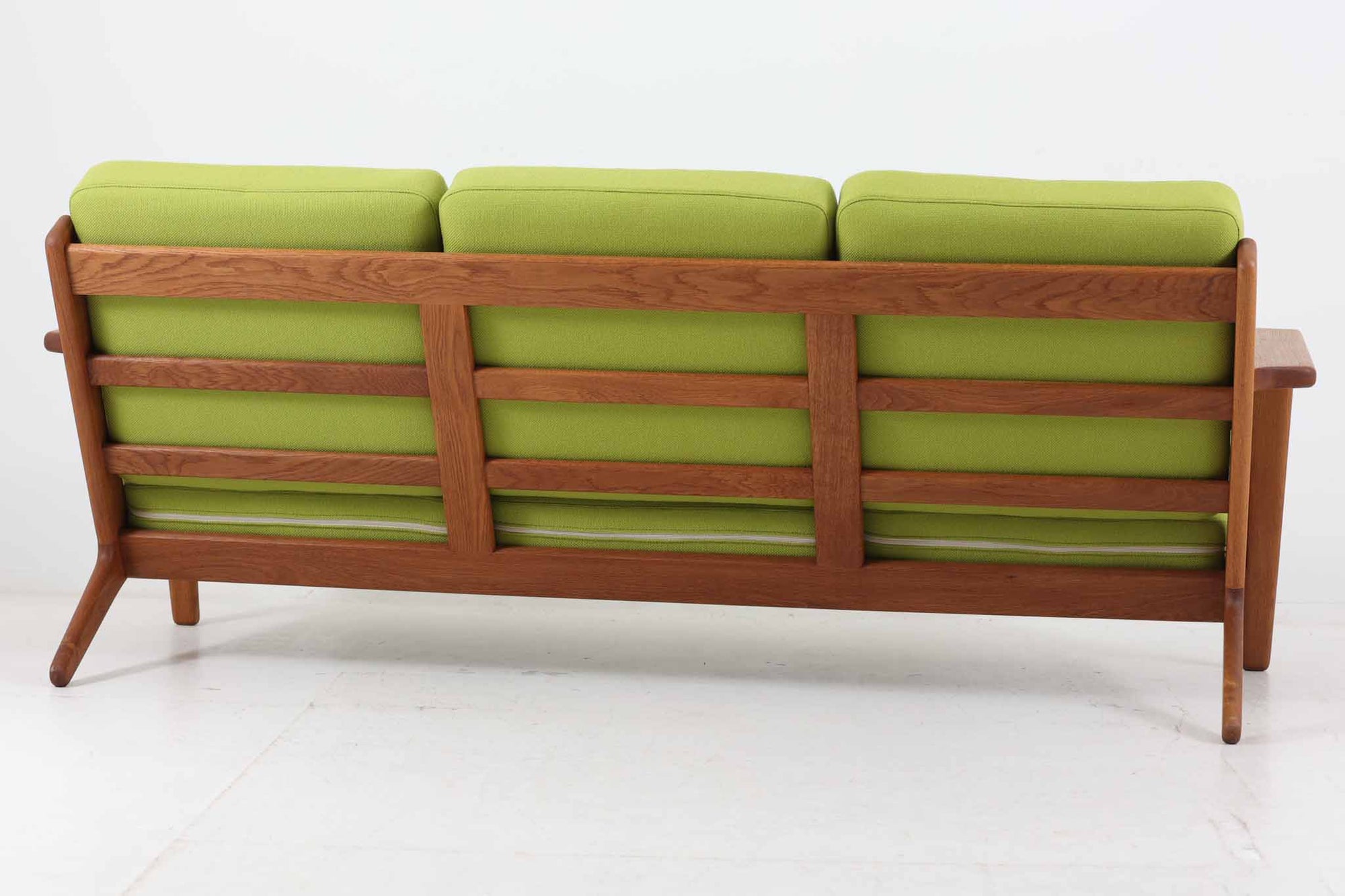 北欧家具を代表するソファ『GE290』です。現在リプロダクト品が販売されていますが、こちらは本物です。元々はベッド会社であるGETAmA社ならではのコイルスプリングが内包されたクッションの座り心地は、弾力があり心地良く、読書や映画などのリラックスタイムに最適です。立ち上がる際も適度なはね返りがあるので、動く時に億劫になる事はありません。Hans J.Wegnerならではの時代を超えた素晴らしいデザインです。横や背面から見るとまた違った表情を感じて頂けると思います。