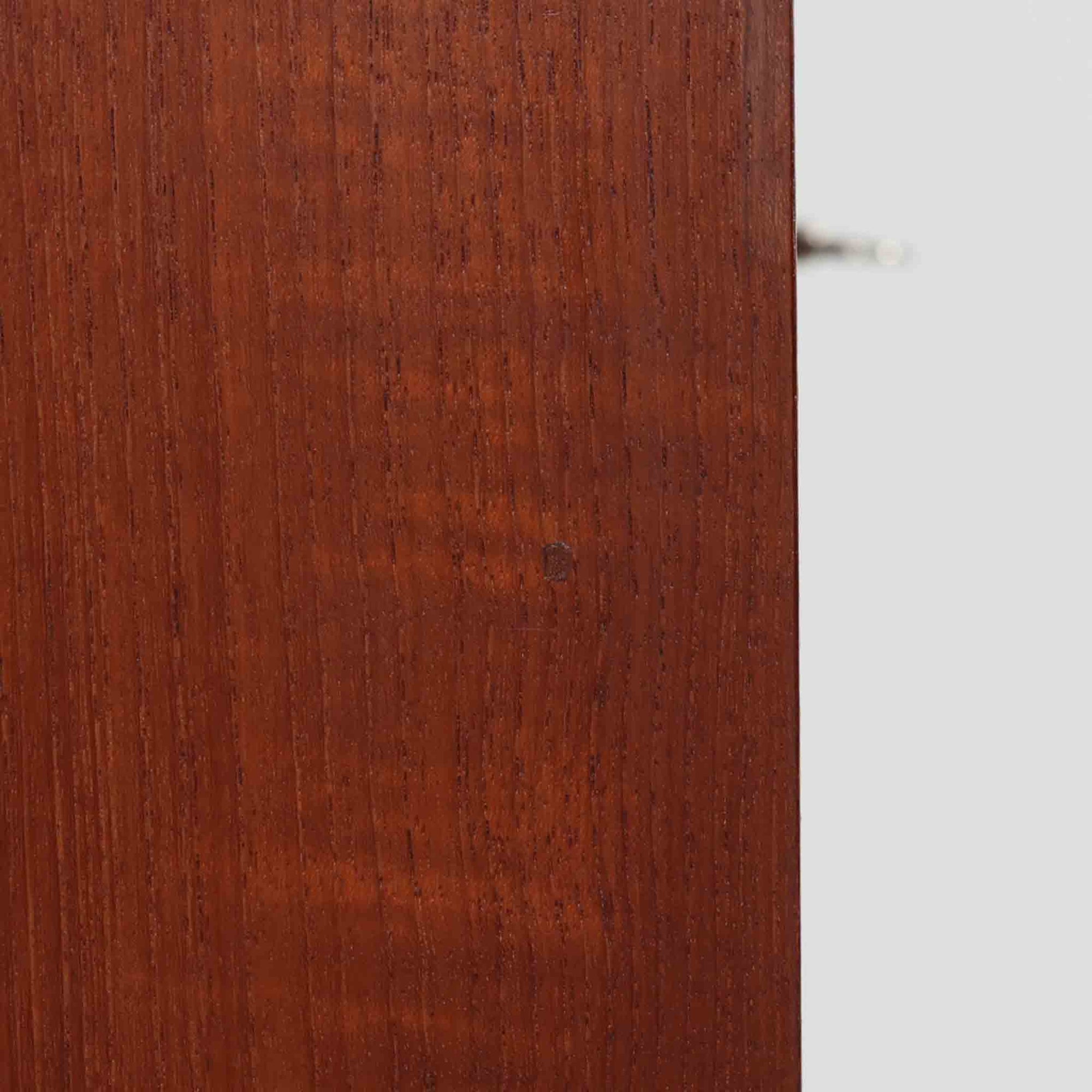 デンマーク製ライティングビューロです。上段には小引き出しと仕切り棚、中央には小さなミラーが備わり、書き物や身支度など多用途にお使いいただけます。チーク材の深みある色合いと滑らかな木目が美しく、シンプルで直線的なフォルムが落ち着いた印象を与えます。引き出しの斜めに削り出された取っ手やテーパー脚など、北欧らしい洗練されたディテールが魅力です。経年により増した艶が味わい深く、リビングや寝室に上品な温もりを添える一台です。