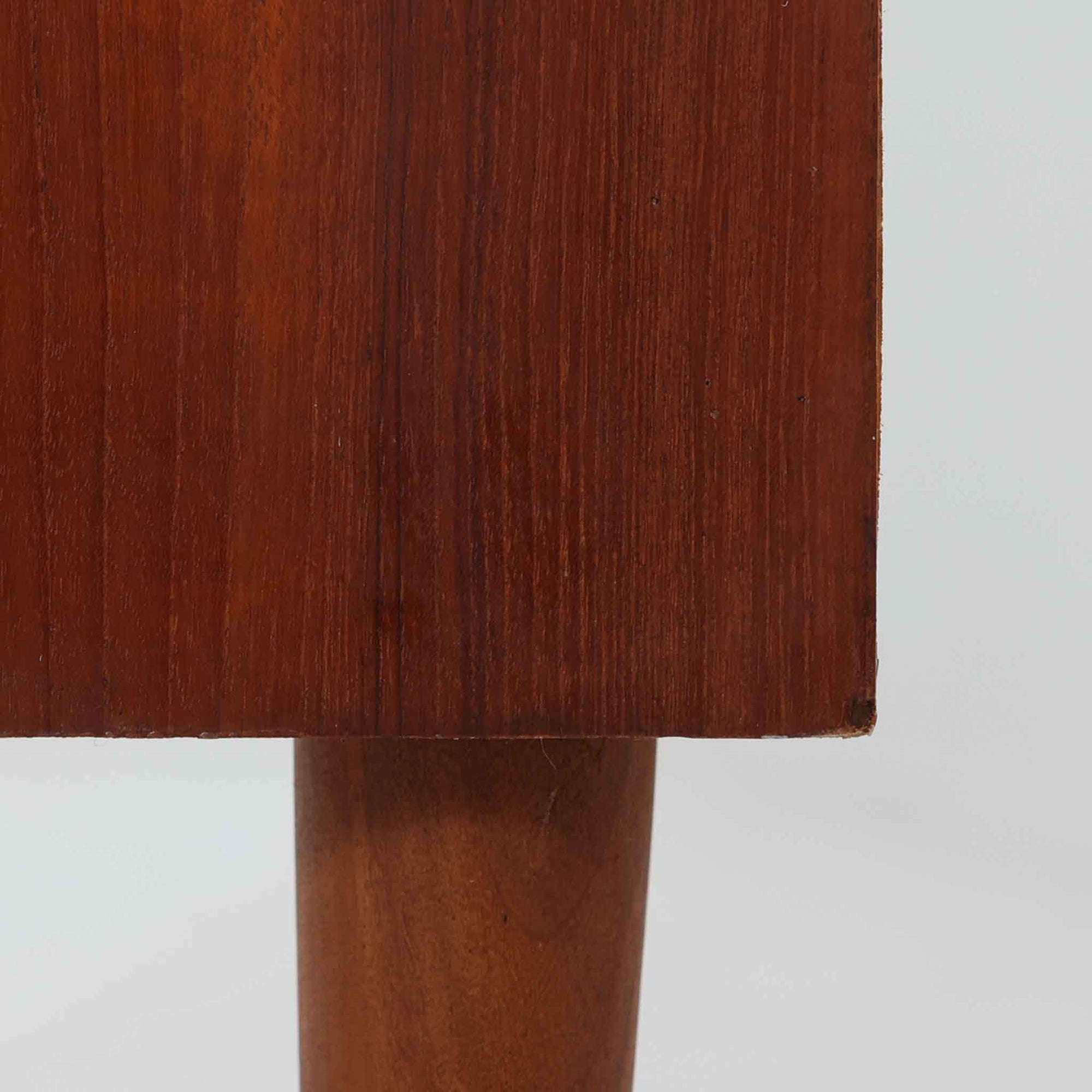 デンマーク製ライティングビューロです。上段には小引き出しと仕切り棚、中央には小さなミラーが備わり、書き物や身支度など多用途にお使いいただけます。チーク材の深みある色合いと滑らかな木目が美しく、シンプルで直線的なフォルムが落ち着いた印象を与えます。引き出しの斜めに削り出された取っ手やテーパー脚など、北欧らしい洗練されたディテールが魅力です。経年により増した艶が味わい深く、リビングや寝室に上品な温もりを添える一台です。