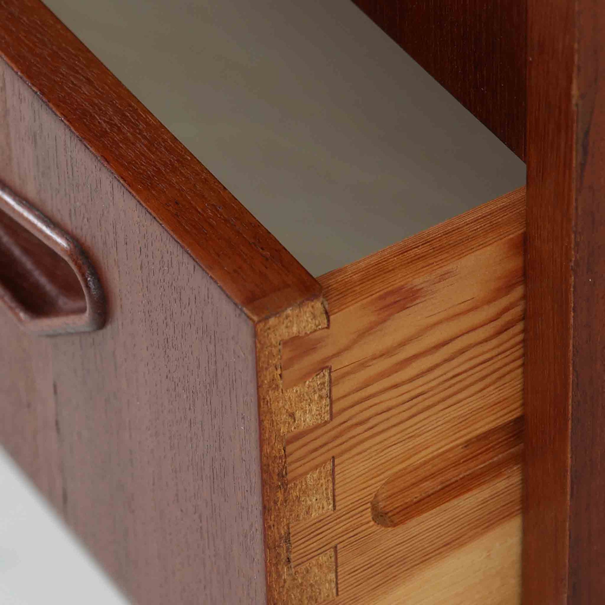 デンマーク製ライティングビューロです。上段には小引き出しと仕切り棚、中央には小さなミラーが備わり、書き物や身支度など多用途にお使いいただけます。チーク材の深みある色合いと滑らかな木目が美しく、シンプルで直線的なフォルムが落ち着いた印象を与えます。引き出しの斜めに削り出された取っ手やテーパー脚など、北欧らしい洗練されたディテールが魅力です。経年により増した艶が味わい深く、リビングや寝室に上品な温もりを添える一台です。