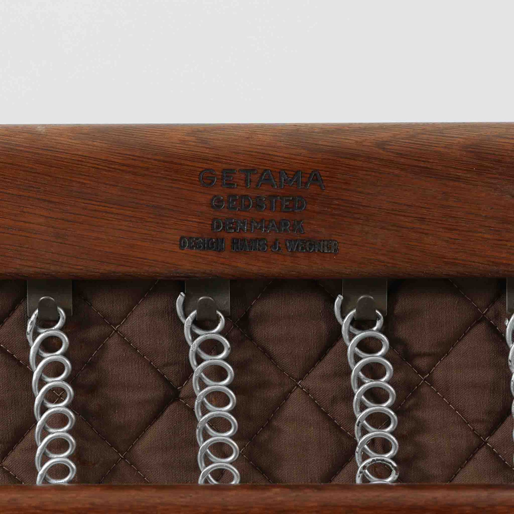 Hans J. Wegnerがデザインし、Getamaが製作したGE290Aハイバックシングルソファです。ダークオーク材の堅牢なフレームは丸みを帯びたアームと後方へ傾斜した脚部が特徴で、身体をやさしく受け止める構造美が際立ちます。張り替えられた落ち着いた色調のクッションは、内部にビンテージ特有のスプリングを内包し、程よい弾力と快適な座り心地を実現。読書や寛ぎの時間に最適で、経年により深みを増した木部の質感が北欧ビンテージならではの存在感と上質な雰囲気を空間に添える一脚です。