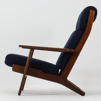 Hans J. Wegnerがデザインし、Getamaが製作したGE290Aハイバックシングルソファです。ダークオーク材の堅牢なフレームは丸みを帯びたアームと後方へ傾斜した脚部が特徴で、身体をやさしく受け止める構造美が際立ちます。張り替えられた落ち着いた色調のクッションは、内部にビンテージ特有のスプリングを内包し、程よい弾力と快適な座り心地を実現。読書や寛ぎの時間に最適で、経年により深みを増した木部の質感が北欧ビンテージならではの存在感と上質な雰囲気を空間に添える一脚です。