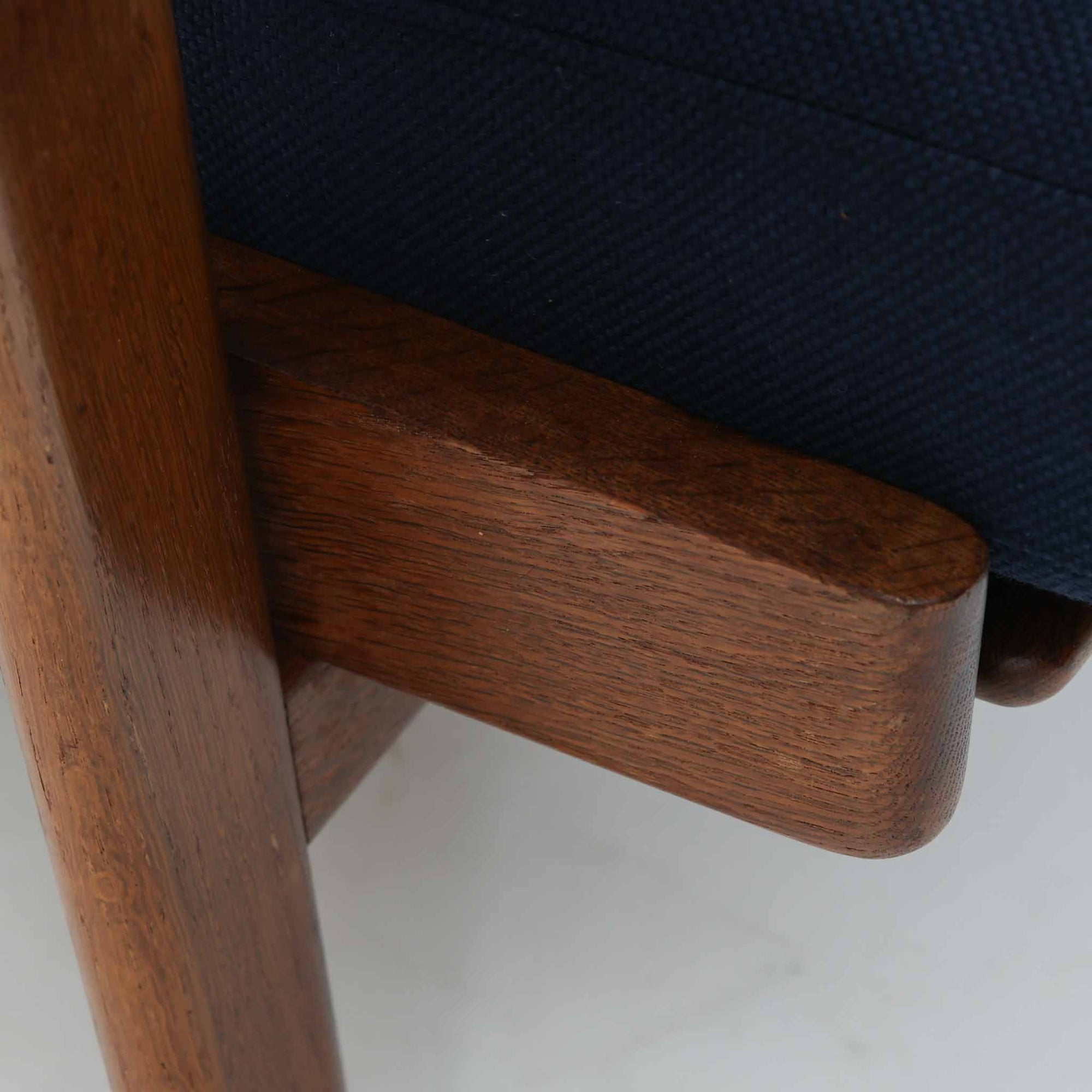 Hans J. Wegnerがデザインし、Getamaが製作したGE290Aハイバックシングルソファです。ダークオーク材の堅牢なフレームは丸みを帯びたアームと後方へ傾斜した脚部が特徴で、身体をやさしく受け止める構造美が際立ちます。張り替えられた落ち着いた色調のクッションは、内部にビンテージ特有のスプリングを内包し、程よい弾力と快適な座り心地を実現。読書や寛ぎの時間に最適で、経年により深みを増した木部の質感が北欧ビンテージならではの存在感と上質な雰囲気を空間に添える一脚です。