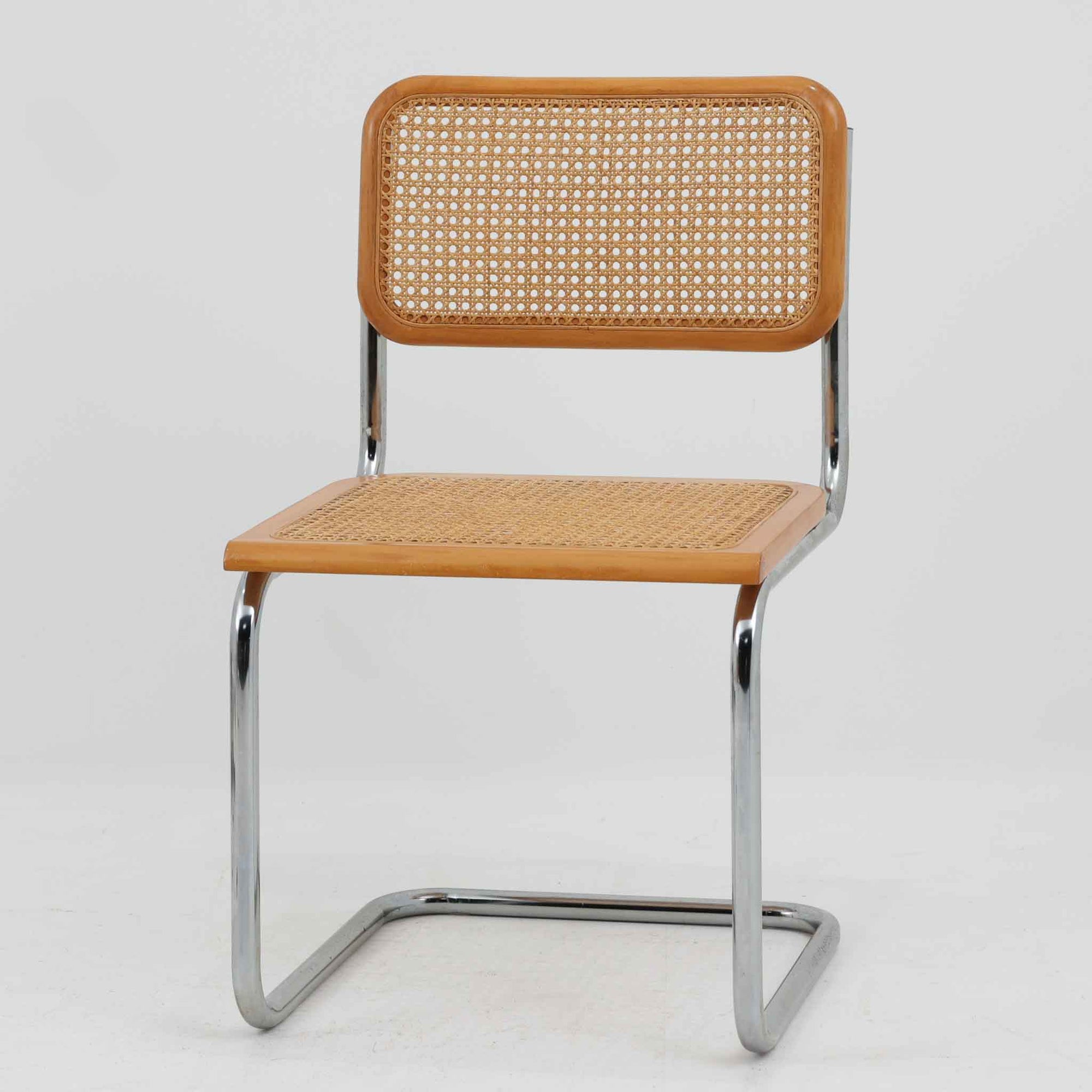 Marcel Breuerによる名作「Cesca Chair」です。ビーチ材のフレームにラタン張りの背もたれと座面を組み合わせ、軽やかな印象と快適な座り心地を実現しています。スチールパイプによるキャンティレバー構造が特徴で、浮遊感のある美しいフォルムはモダンデザインの象徴として高く評価されています。異素材が調和した洗練された佇まいはダイニングや書斎、店舗空間にもおすすめです。長年愛され続けるデザインとビンテージならではの風合いをお楽しみいただける一脚です。こちらのCesca Chairは、リプロダクト（復刻版）品となります。多くのリプロダクトが市場に出回っており、北欧地域でも使用されていることが確認されています。また、本チェアはデンマークディーラーより買い付けた品物になりますが、生産国、製造メーカーについては不明です。