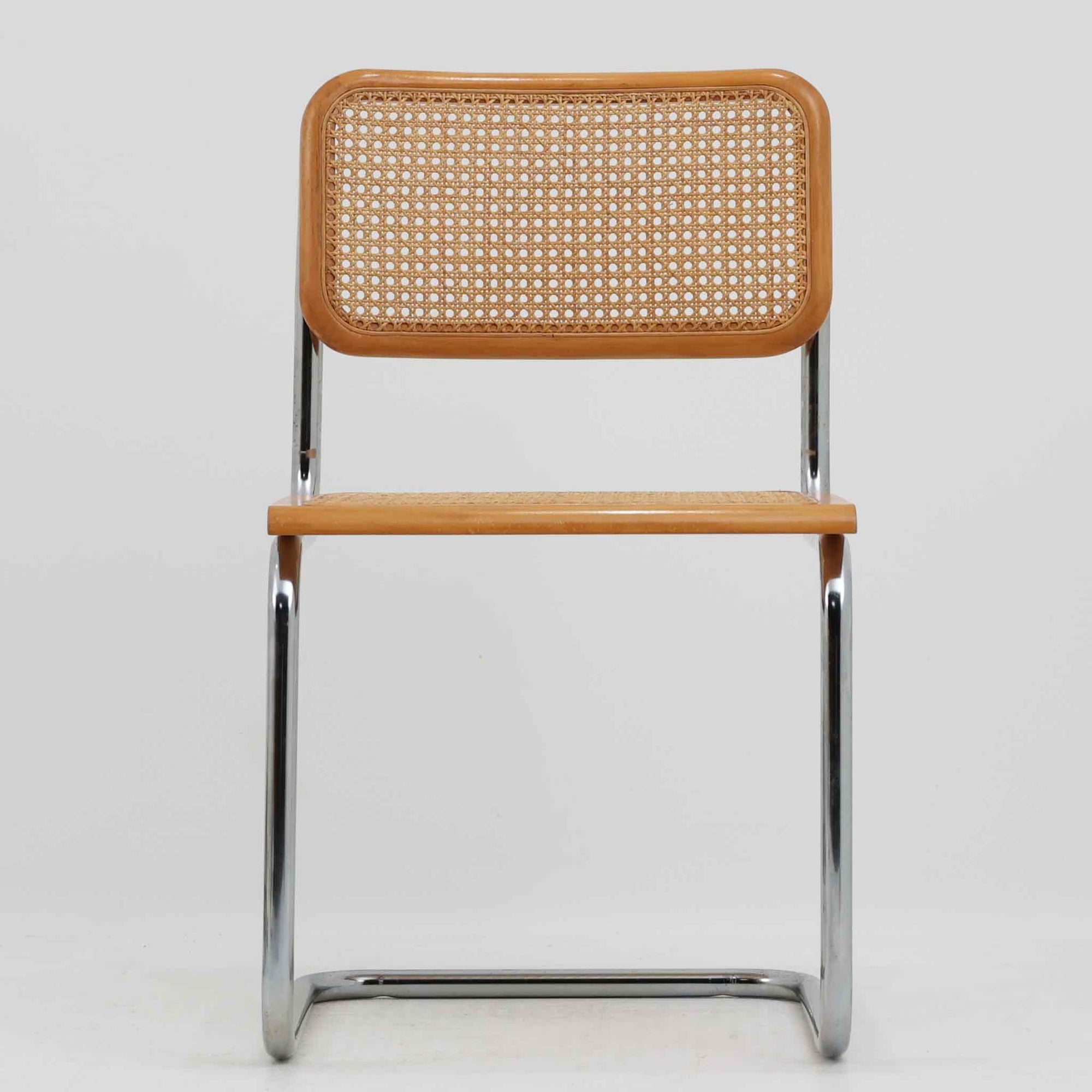 Marcel Breuerによる名作「Cesca Chair」です。ビーチ材のフレームにラタン張りの背もたれと座面を組み合わせ、軽やかな印象と快適な座り心地を実現しています。スチールパイプによるキャンティレバー構造が特徴で、浮遊感のある美しいフォルムはモダンデザインの象徴として高く評価されています。異素材が調和した洗練された佇まいはダイニングや書斎、店舗空間にもおすすめです。長年愛され続けるデザインとビンテージならではの風合いをお楽しみいただける一脚です。こちらのCesca Chairは、リプロダクト（復刻版）品となります。多くのリプロダクトが市場に出回っており、北欧地域でも使用されていることが確認されています。また、本チェアはデンマークディーラーより買い付けた品物になりますが、生産国、製造メーカーについては不明です。