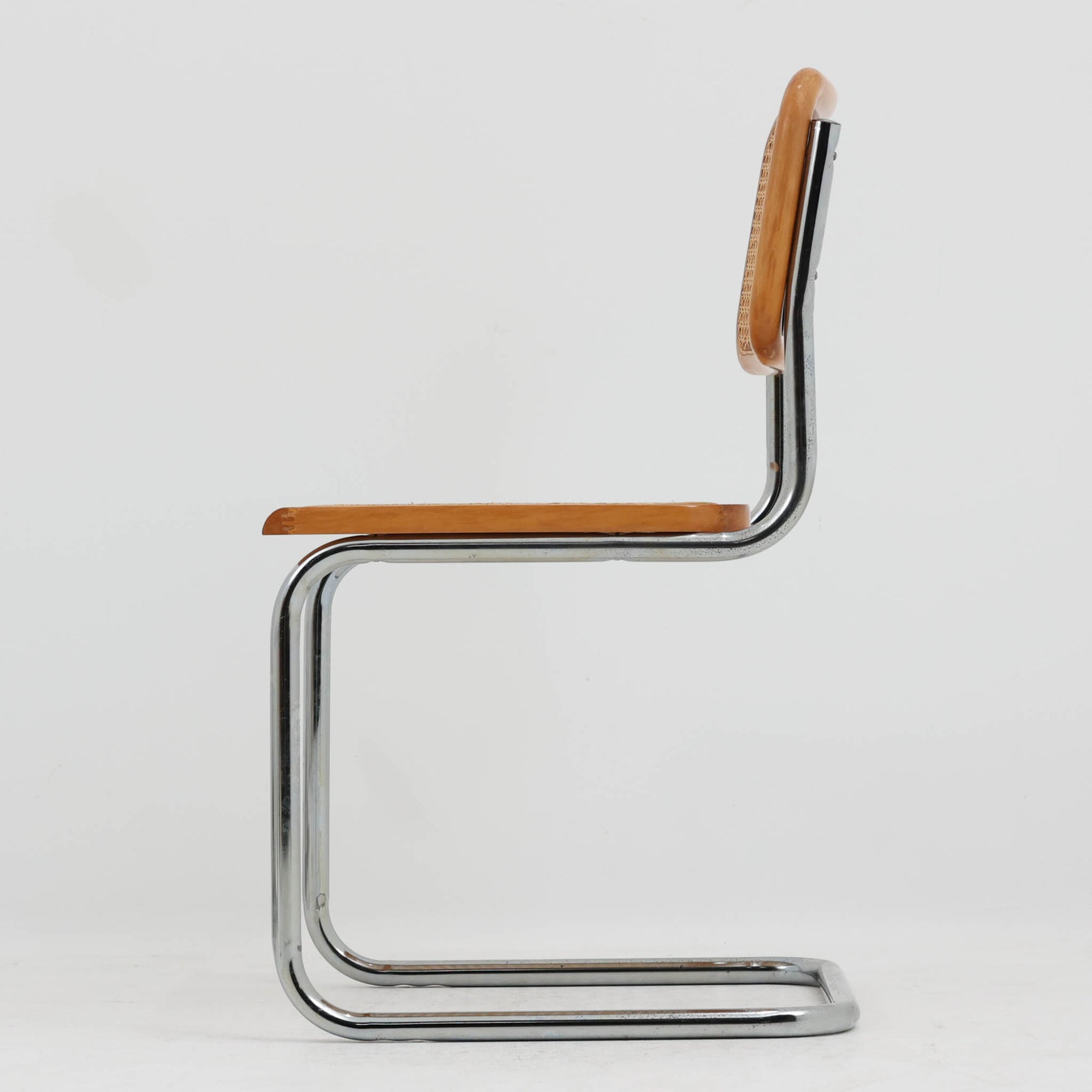 Marcel Breuerによる名作「Cesca Chair」です。ビーチ材のフレームにラタン張りの背もたれと座面を組み合わせ、軽やかな印象と快適な座り心地を実現しています。スチールパイプによるキャンティレバー構造が特徴で、浮遊感のある美しいフォルムはモダンデザインの象徴として高く評価されています。異素材が調和した洗練された佇まいはダイニングや書斎、店舗空間にもおすすめです。長年愛され続けるデザインとビンテージならではの風合いをお楽しみいただける一脚です。こちらのCesca Chairは、リプロダクト（復刻版）品となります。多くのリプロダクトが市場に出回っており、北欧地域でも使用されていることが確認されています。また、本チェアはデンマークディーラーより買い付けた品物になりますが、生産国、製造メーカーについては不明です。