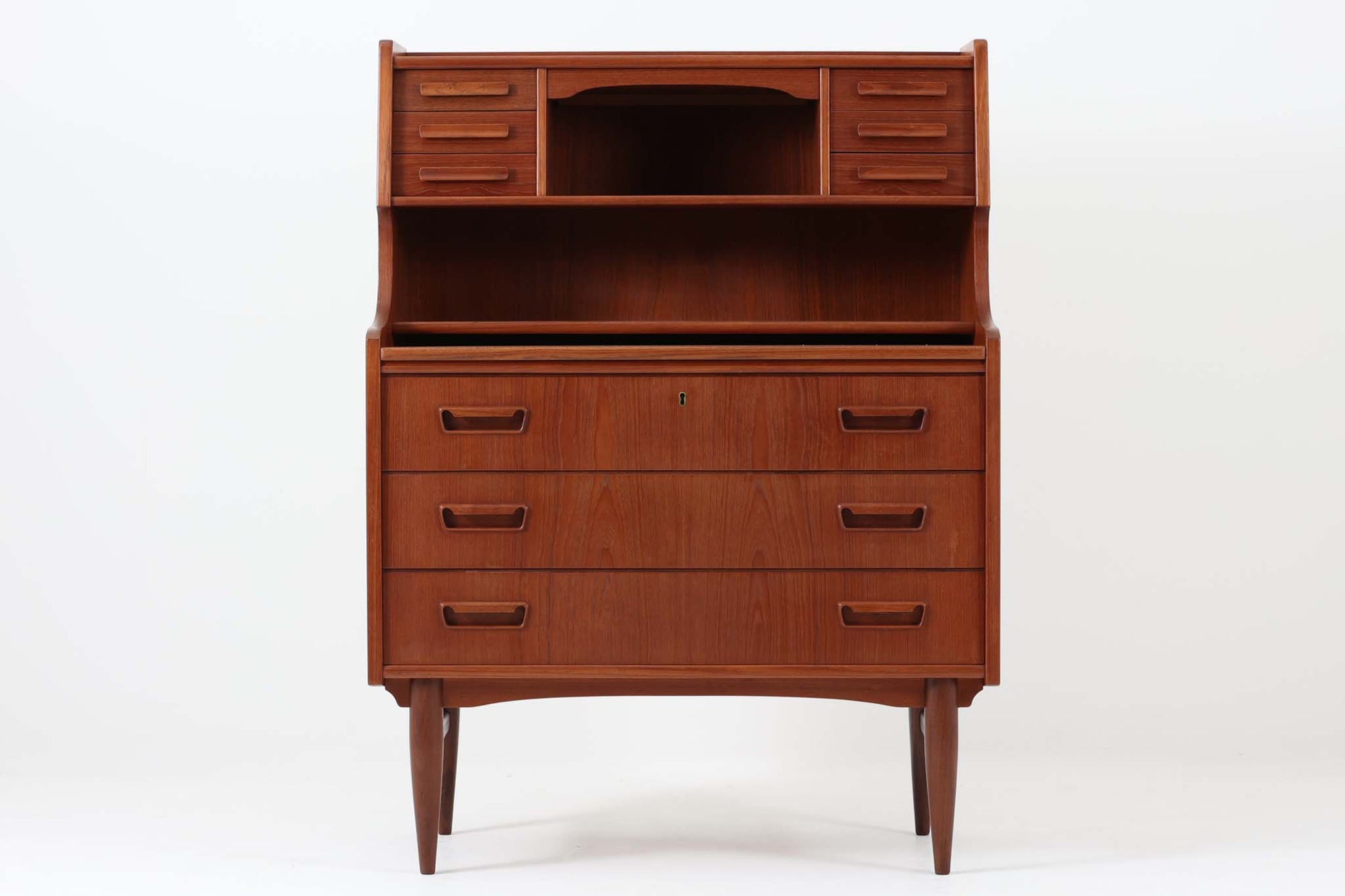 こちらのライティングビューロは、鏡が付属しています。背が少し高めで、小引き出し6杯、大きな引き出し3杯があり、十分な収納力が備わっています。脚の幕板の形状もデザイン性があり、本体には良質なチーク材が使用されており、上品な雰囲気です。