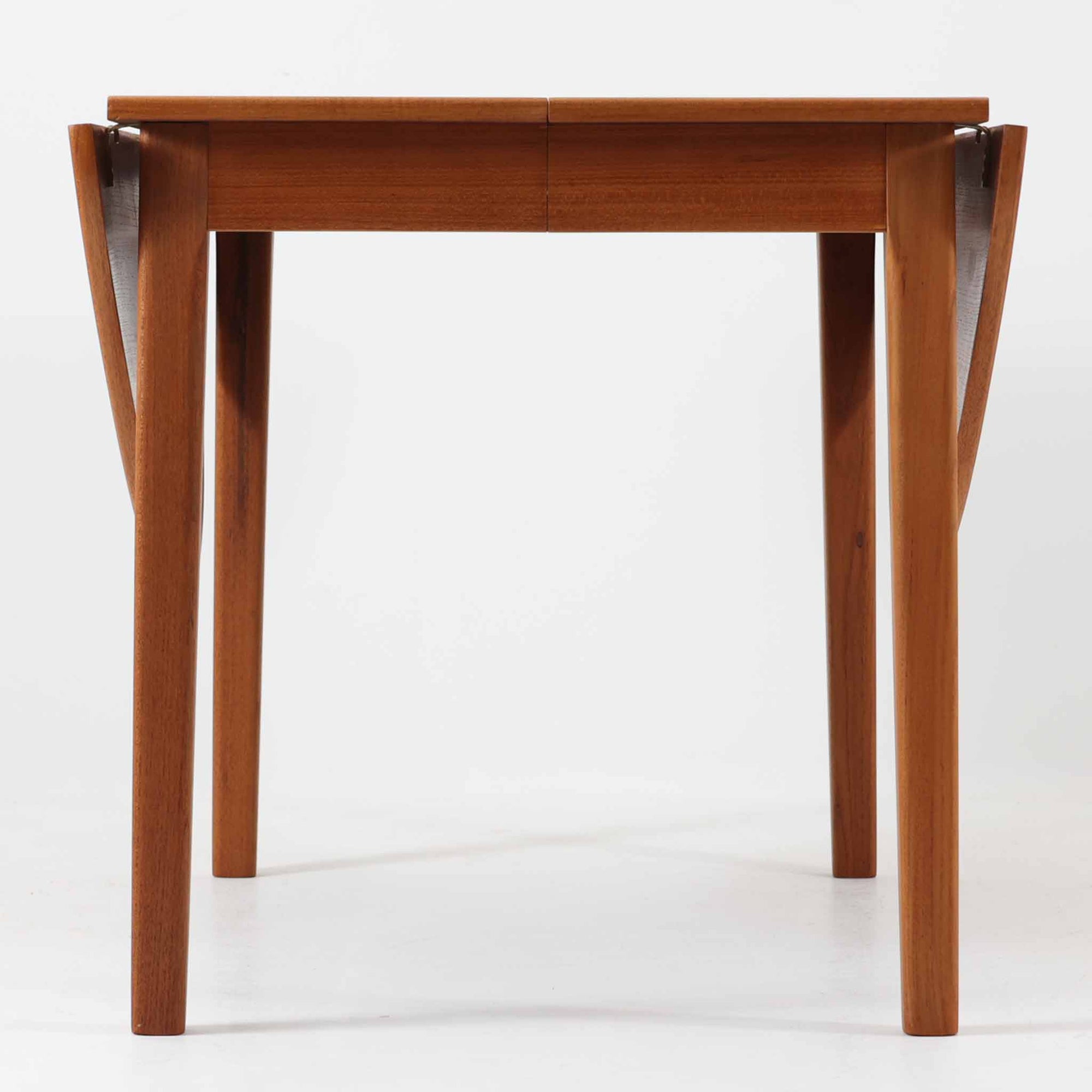 CJ Rosengaarden社によるエクステンションダイニングテーブルは、長方形の本体に両側バタフライ式の半円天板と中央拡張板2枚を備え、最大で8人がゆったりと囲める広さに対応します。温かみのあるチーク材と美しい木目、滑らかな金属レールによる開閉構造が魅力で、シーンに応じて柔軟に使える北欧ビンテージ家具の実用的な一台です。