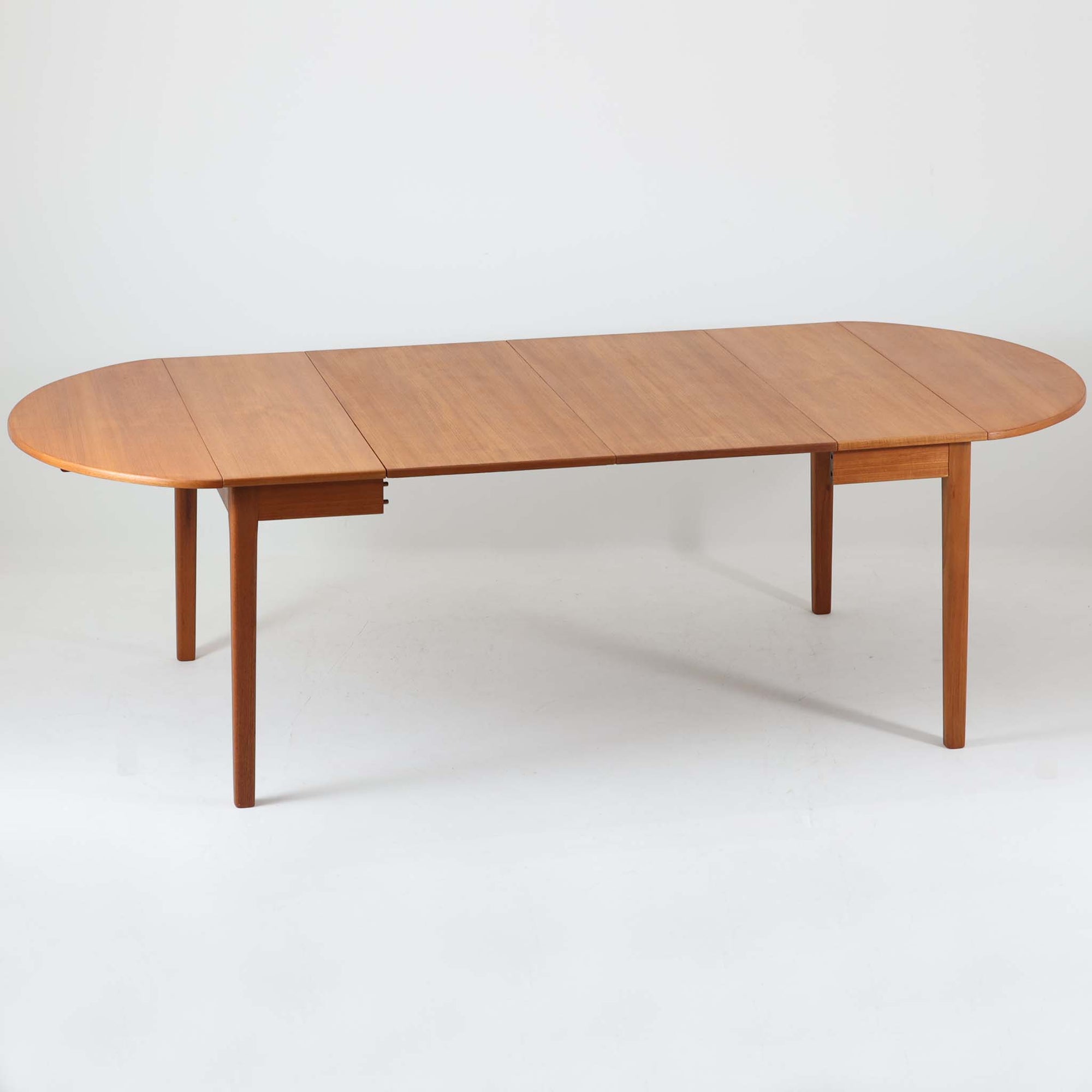 CJ Rosengaarden社によるエクステンションダイニングテーブルは、長方形の本体に両側バタフライ式の半円天板と中央拡張板2枚を備え、最大で8人がゆったりと囲める広さに対応します。温かみのあるチーク材と美しい木目、滑らかな金属レールによる開閉構造が魅力で、シーンに応じて柔軟に使える北欧ビンテージ家具の実用的な一台です。