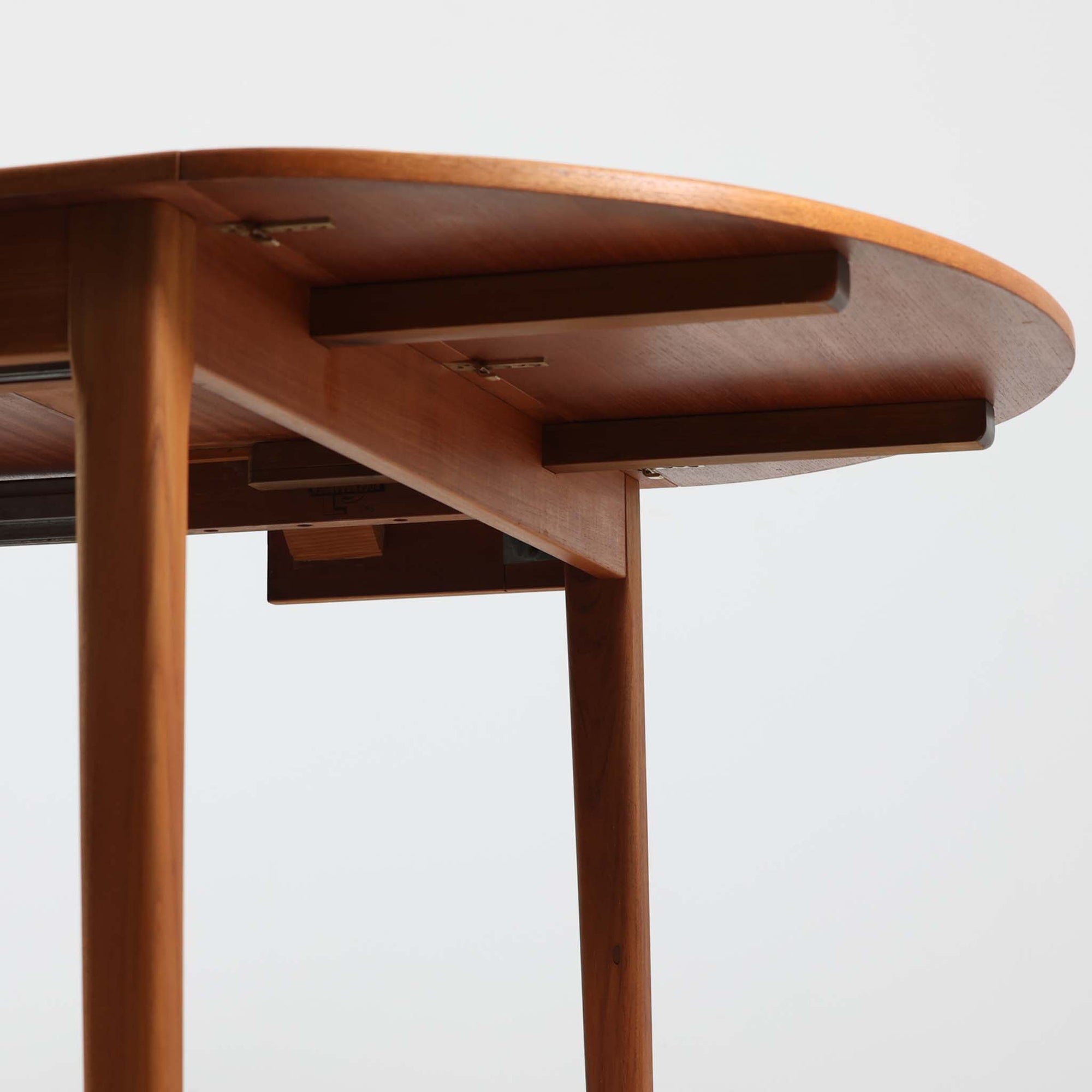 CJ Rosengaarden社によるエクステンションダイニングテーブルは、長方形の本体に両側バタフライ式の半円天板と中央拡張板2枚を備え、最大で8人がゆったりと囲める広さに対応します。温かみのあるチーク材と美しい木目、滑らかな金属レールによる開閉構造が魅力で、シーンに応じて柔軟に使える北欧ビンテージ家具の実用的な一台です。