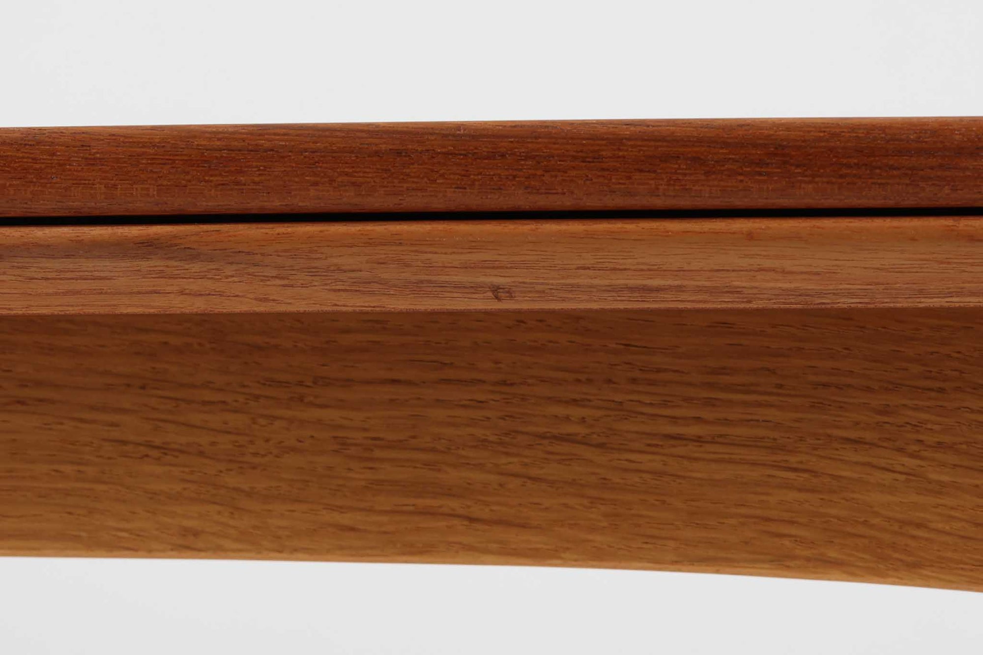 デンマークの名工Slagelse mobelvaerk社が手掛けたこちらのダイニングテーブルは、アーチ状の幕板が特徴であり、異なる素材の組み合わせが美しさを際立たせます。天板には上質なチーク材が用いられ、脚部にはナチュラルなオーク材が採用されています。また、幕板は強度と使い勝手が考慮され、通常時には4人、拡張時には6～8人が快適に使用できる設計となっています。