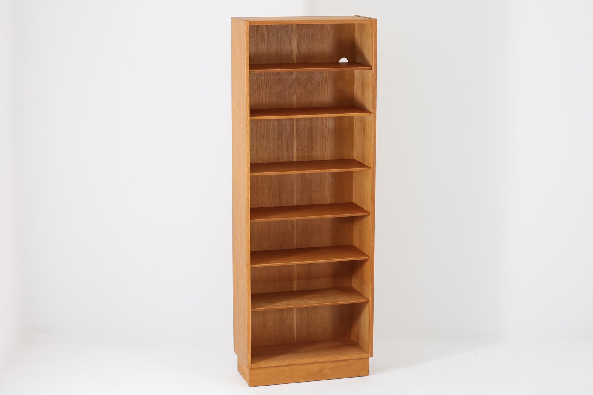 Hundevad &amp; Co社製の造りが良いブックシェルフです。良質なオーク材が使用されています。大型で様々な本が収納可能です。Poul Hundevadならではの棚板前面のスリットとタボが見えない設計により非常にすっきりとした印象に仕上がっています。通常は台輪が側面とフラットなのですが、こちらのシェルフは台輪が少し内側に入っています。デンマーク購入時よりこの仕様ですので、予めご了承くださいませ。