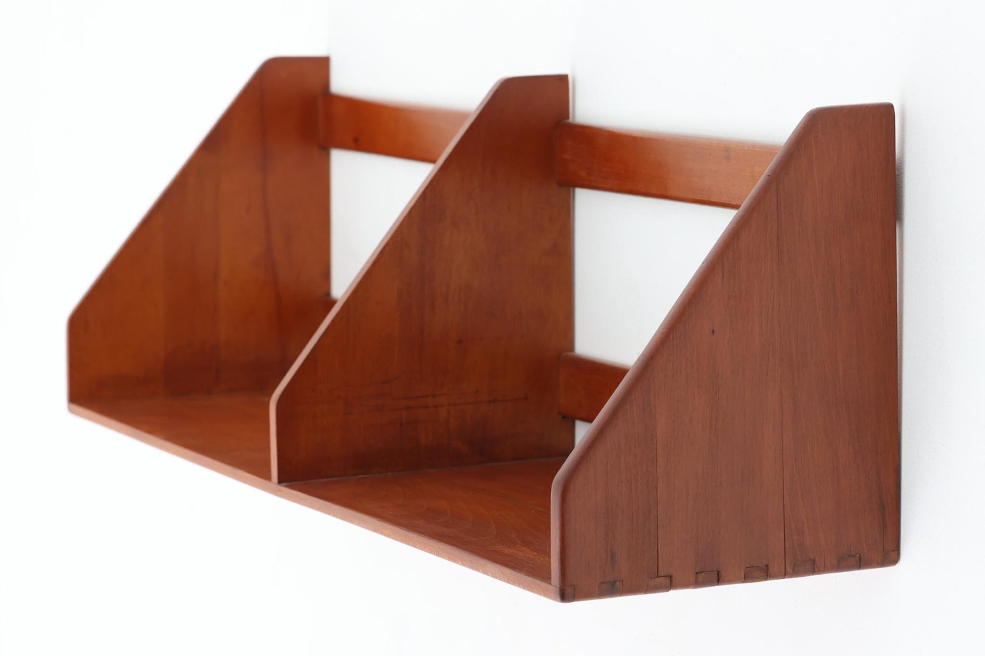 デンマークの国民的家具ブランドFDBモブラーより、Borge mogensen（ボーエ・モーエンセン）によるウォールシェルフのご紹介です。無垢のビーチ材で構成された本体は温かみのある色合いで、直線を基調としたシンプルなデザインが特徴です。三つに仕切られた収納スペースには本や雑誌を立てて収納することができ、壁掛け式で圧迫感が少なく実用性と美しさを兼ね備えています。背面にはFDBモブラーの焼印が確認できます。北欧らしい温もりのある佇まいが、お部屋に落ち着いた雰囲気を与えてくれる一品です。