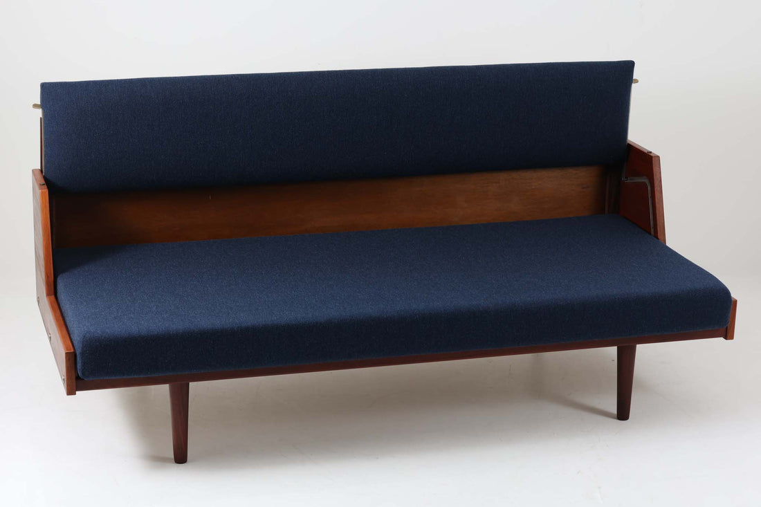 デンマークの名門家具メーカーGetama（ゲタマ）より、Hans J. Wegner（ハンス・J・ウェグナー）によってデザインされたビンテージのデイベッド「GE258」のご紹介です。チーク材のフレームに、希少な丸脚仕様が特徴的なモデルで、無駄のない美しい直線と有機的なフォルムが融合した北欧モダンデザインの代表作です。背もたれを後方に倒すことでベッドとしてもご使用いただける実用性の高い構造で、張地は落ち着いたネイビー系のファブリックで張り替え済みです。チーク材の木目が美しく、経年による味わいも感じられる逸品です。