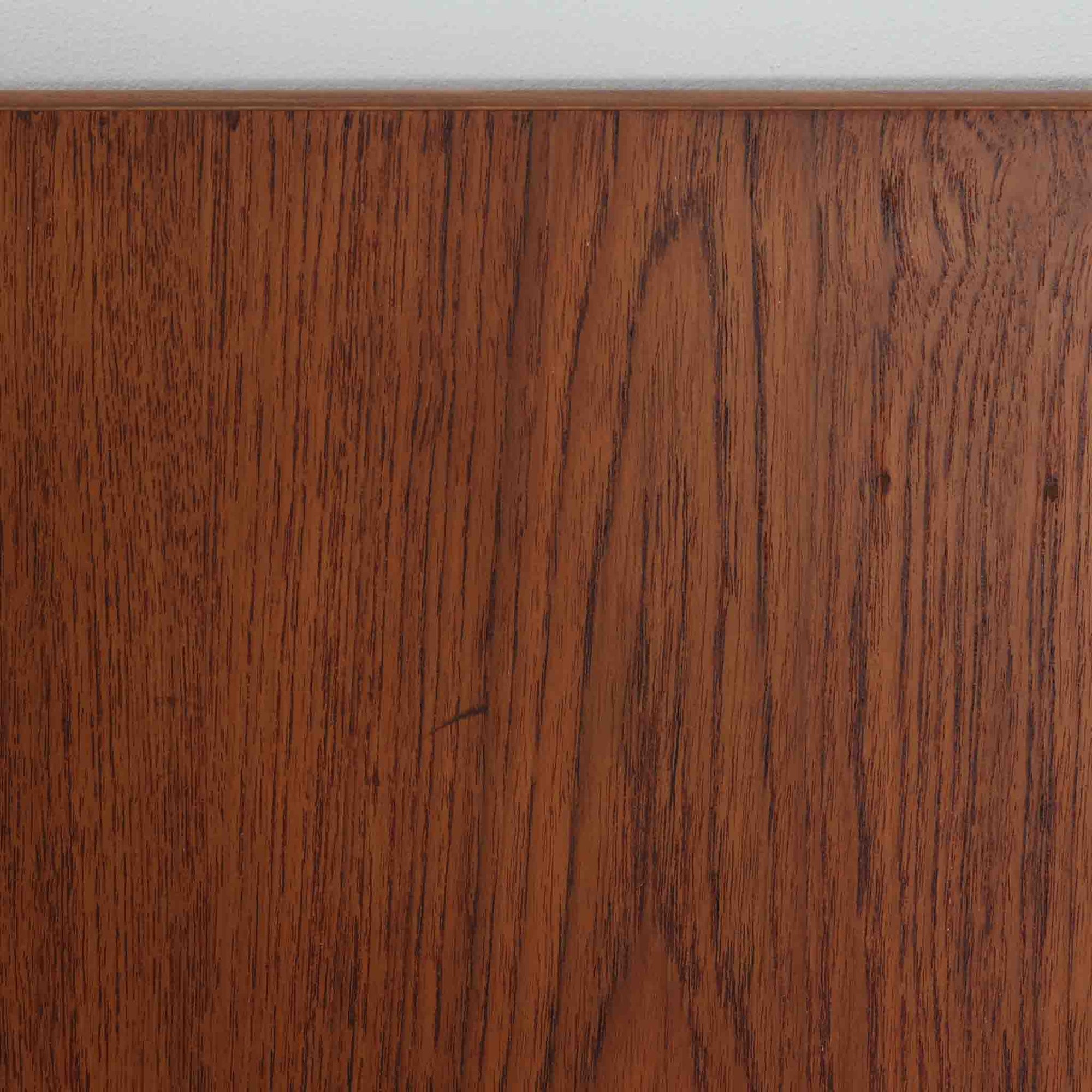 Borge Mogensen（ボーエ・モーエンセン）がFDB Moblerのために手掛けたC18ダイニングテーブルは、チーク材天板とオーク材脚部を組み合わせた北欧モダンを象徴するビンテージ家具で、直線的で端正なプロポーションと安定感のあるT字脚構造が特徴です。拡張板を備え、来客時や家族構成の変化にも柔軟に対応でき、日常使いから特別な食卓まで幅広く活躍します。現在はCarl Hansen &amp; Son社より復刻生産されていますが、チーク材天板とオーク材脚部という素材の組み合わせは当時のビンテージ品ならではの仕様で、脚部に用いられた真鍮製の留め具も現行品とは異なる形状となっています。経年により深みを増した木肌と、実用性を重視したモーエンセンらしい設計思想、そしてビンテージならではのディテールを味わえる一台です。