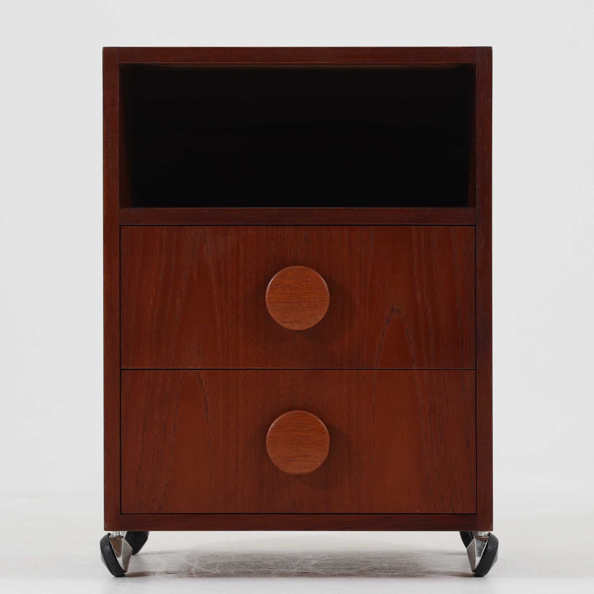 特徴的な丸型取手が目を引くこちらのサイドテーブルは、温かみのあるチーク材とシンプルな構造美が調和した北欧ビンテージ家具です。オープンスペースと2杯の引き出しに加え、英国製「ORBIT」キャスターを備え、滑らかな移動が可能です。幅40cmとコンパクトながらも機能性に優れており、ベッドサイドやソファ横の収納兼テーブルとして幅広く活躍します。実用性と遊び心を兼ね備えた一点物として、空間に心地よいアクセントを加えてくれます。