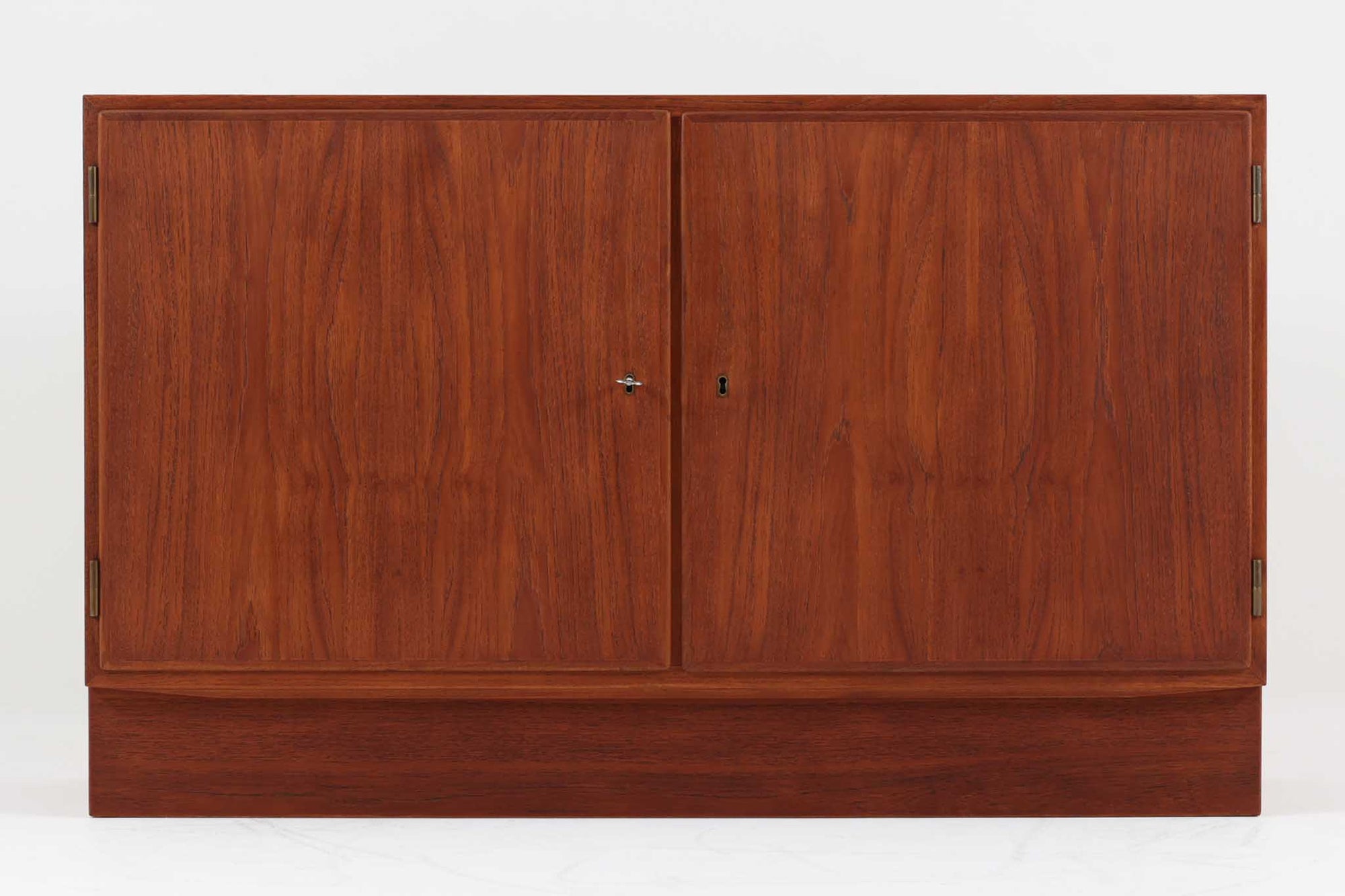 Poul Hundevadデザインのキャビネットです。扉の取手に鍵を使用したデンマークならではのデザインで、シンプルな本体には扉のみが設置されています。北欧から買い付けたもので、良質なチーク材が使用され、温かみのある雰囲気を醸し出します。製造はHundevad自身の家具工房、Hundevad&Co.によるもので、デンマークの厳しい品質基準を満たした「DANISH FURNITUREmAKE'S CONTROL」の刻印が施されています。さらに、小引き出しや高さ調整可能な棚板が備わっており、機能性も兼ね備えた優れたアイテムです。