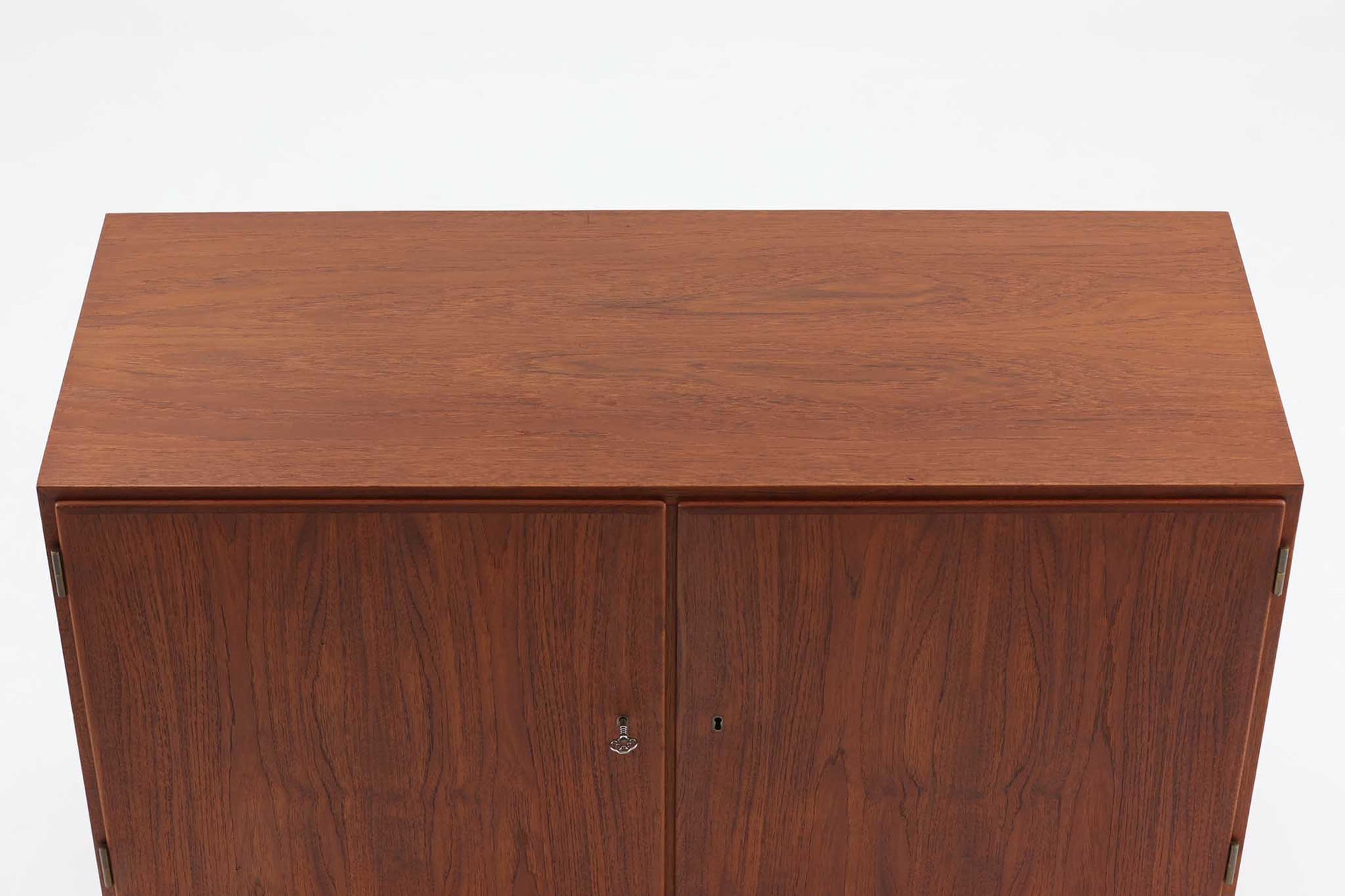 Poul Hundevadデザインのキャビネットです。扉の取手に鍵を使用したデンマークならではのデザインで、シンプルな本体には扉のみが設置されています。北欧から買い付けたもので、良質なチーク材が使用され、温かみのある雰囲気を醸し出します。製造はHundevad自身の家具工房、Hundevad&amp;Co.によるもので、デンマークの厳しい品質基準を満たした「DANISH FURNITUREmAKE'S CONTROL」の刻印が施されています。さらに、小引き出しや高さ調整可能な棚板が備わっており、機能性も兼ね備えた優れたアイテムです。