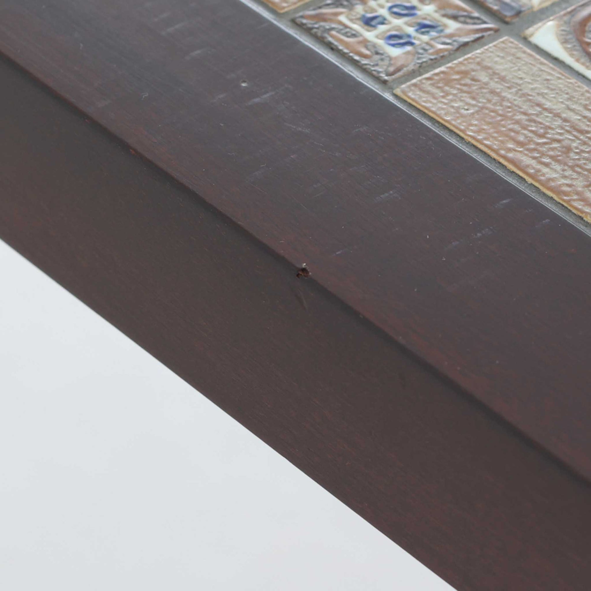 Severin Hansen Jr.によってデザインされ、Haslev社から製造されたセンターテーブルは、マホガニー材のフレームにロイヤルコペンハーゲン製Bacaシリーズのタイルをあしらった上質な一台です。精緻なカットが施された脚部と幾何学的なタイル装飾が調和し、クラフトマンシップと芸術性を兼ね備えた北欧ビンテージらしい佇まいを見せています。幅133cmのサイズ感はリビングの主役として十分な存在感を放ち、コーヒーテーブルとしてはもちろん、装飾台としてもおすすめです。