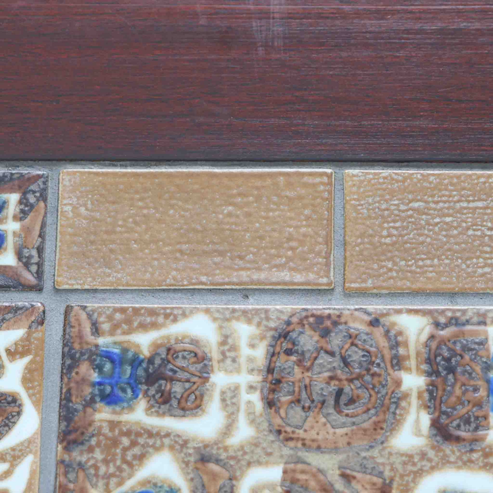 Severin Hansen Jr.によってデザインされ、Haslev社から製造されたセンターテーブルは、マホガニー材のフレームにロイヤルコペンハーゲン製Bacaシリーズのタイルをあしらった上質な一台です。精緻なカットが施された脚部と幾何学的なタイル装飾が調和し、クラフトマンシップと芸術性を兼ね備えた北欧ビンテージらしい佇まいを見せています。幅133cmのサイズ感はリビングの主役として十分な存在感を放ち、コーヒーテーブルとしてはもちろん、装飾台としてもおすすめです。