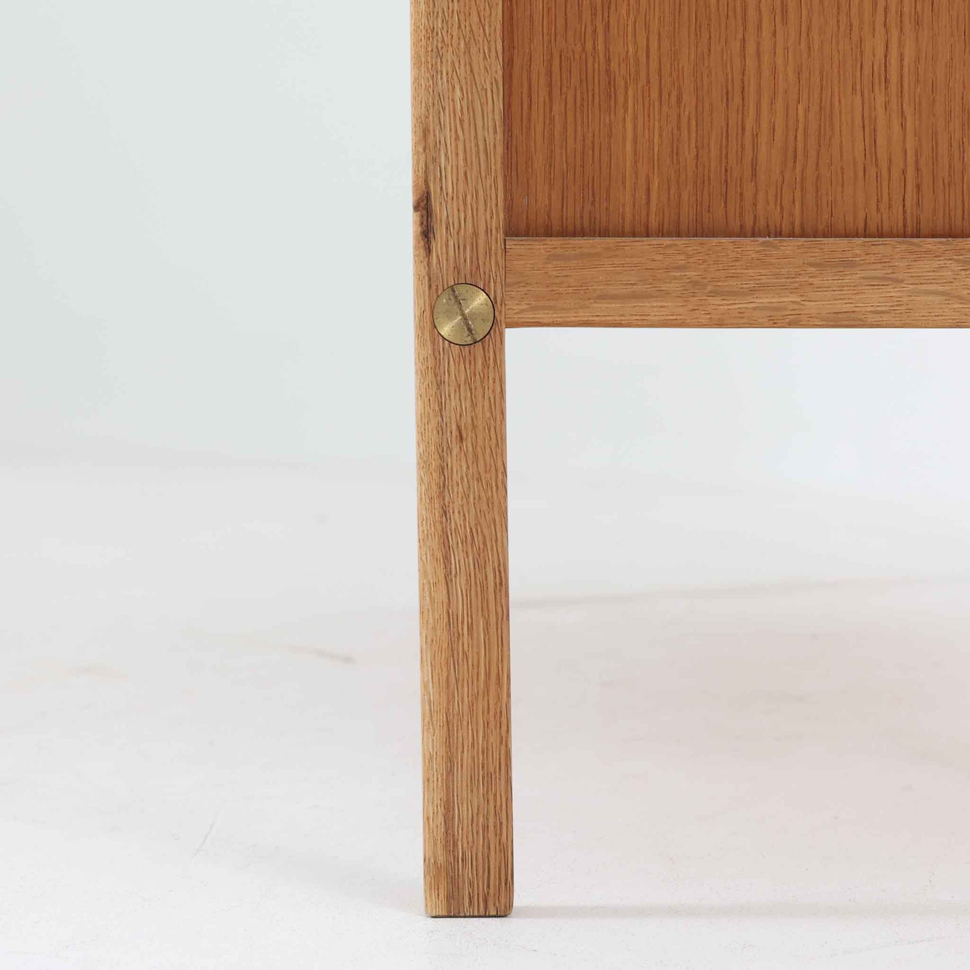 B. Fridhagenがデザインし、スウェーデンのBodafors社によって製造されたこちらのボードは、上質なオーク材を用いた小ぶりなサイズ感と、無駄を省いた洗練された意匠が魅力の一台です。スライド扉を開けると左右に仕切られた収納部が現れ、日用品や書籍の整理に最適です。細身の脚と角の立ったフレームが全体に軽やかな印象を与え、空間を圧迫せず設置できます。シンプルながらも素材の美しさと北欧らしい実用性が際立つ、希少なビンテージ家具です。