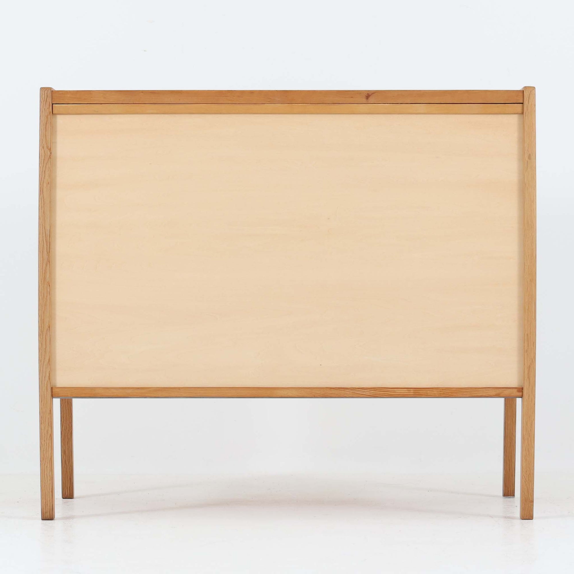 B. Fridhagenがデザインし、スウェーデンのBodafors社によって製造されたこちらのボードは、上質なオーク材を用いた小ぶりなサイズ感と、無駄を省いた洗練された意匠が魅力の一台です。スライド扉を開けると左右に仕切られた収納部が現れ、日用品や書籍の整理に最適です。細身の脚と角の立ったフレームが全体に軽やかな印象を与え、空間を圧迫せず設置できます。シンプルながらも素材の美しさと北欧らしい実用性が際立つ、希少なビンテージ家具です。