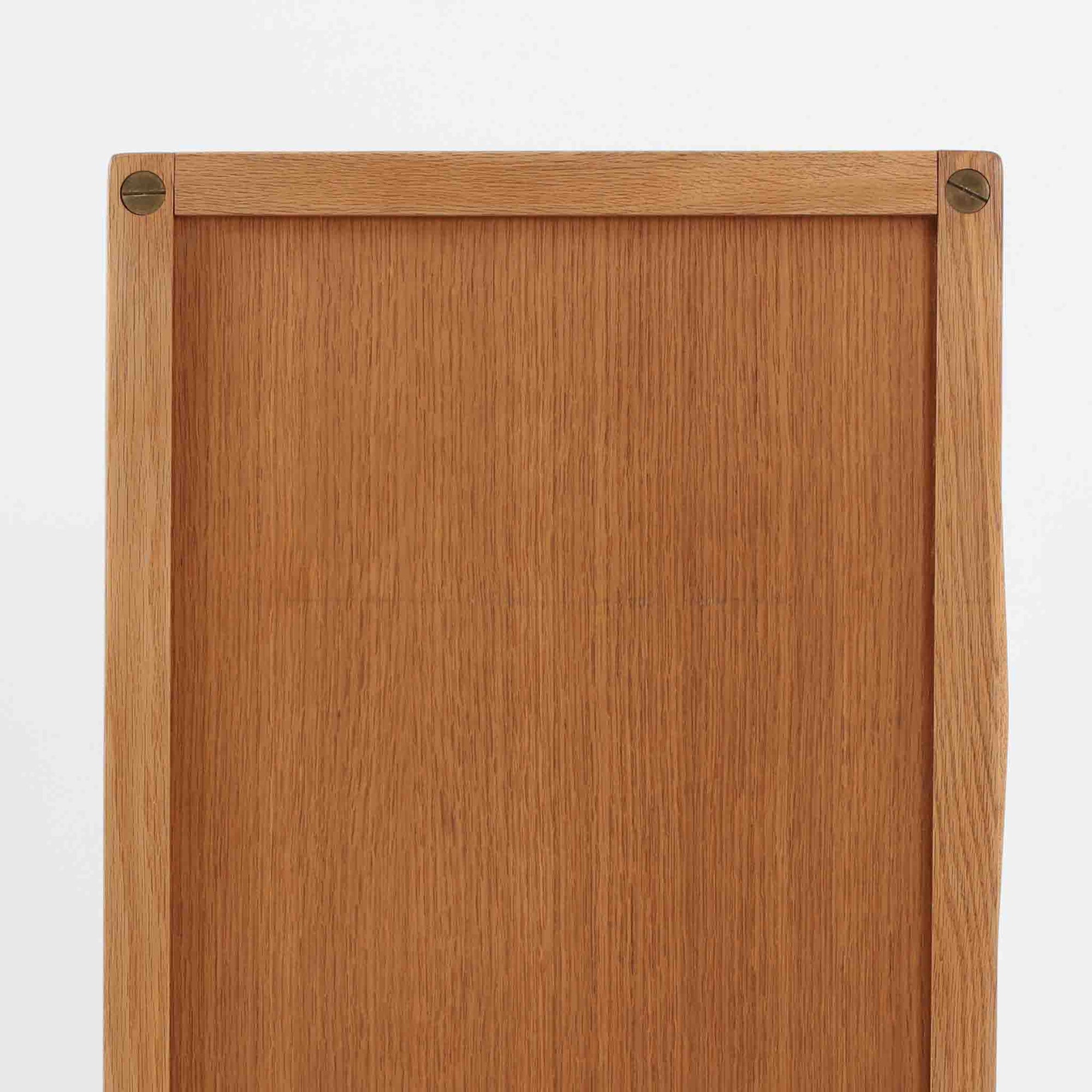 B. Fridhagenがデザインし、スウェーデンのBodafors社によって製造されたこちらのボードは、上質なオーク材を用いた小ぶりなサイズ感と、無駄を省いた洗練された意匠が魅力の一台です。スライド扉を開けると左右に仕切られた収納部が現れ、日用品や書籍の整理に最適です。細身の脚と角の立ったフレームが全体に軽やかな印象を与え、空間を圧迫せず設置できます。シンプルながらも素材の美しさと北欧らしい実用性が際立つ、希少なビンテージ家具です。