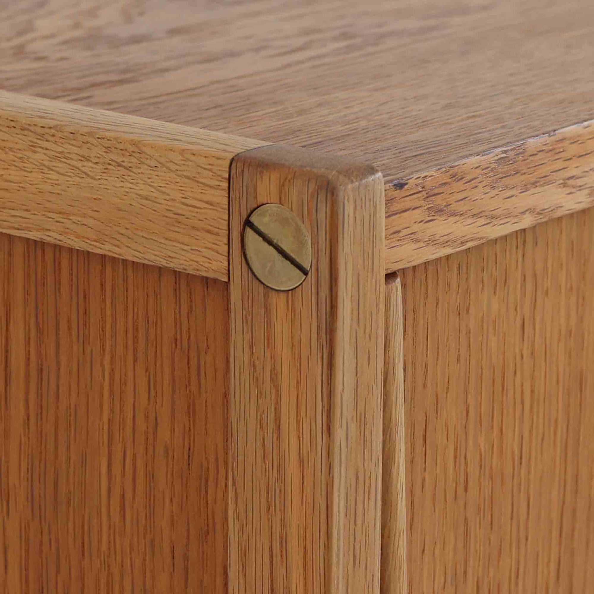 B. Fridhagenがデザインし、スウェーデンのBodafors社によって製造されたこちらのボードは、上質なオーク材を用いた小ぶりなサイズ感と、無駄を省いた洗練された意匠が魅力の一台です。スライド扉を開けると左右に仕切られた収納部が現れ、日用品や書籍の整理に最適です。細身の脚と角の立ったフレームが全体に軽やかな印象を与え、空間を圧迫せず設置できます。シンプルながらも素材の美しさと北欧らしい実用性が際立つ、希少なビンテージ家具です。