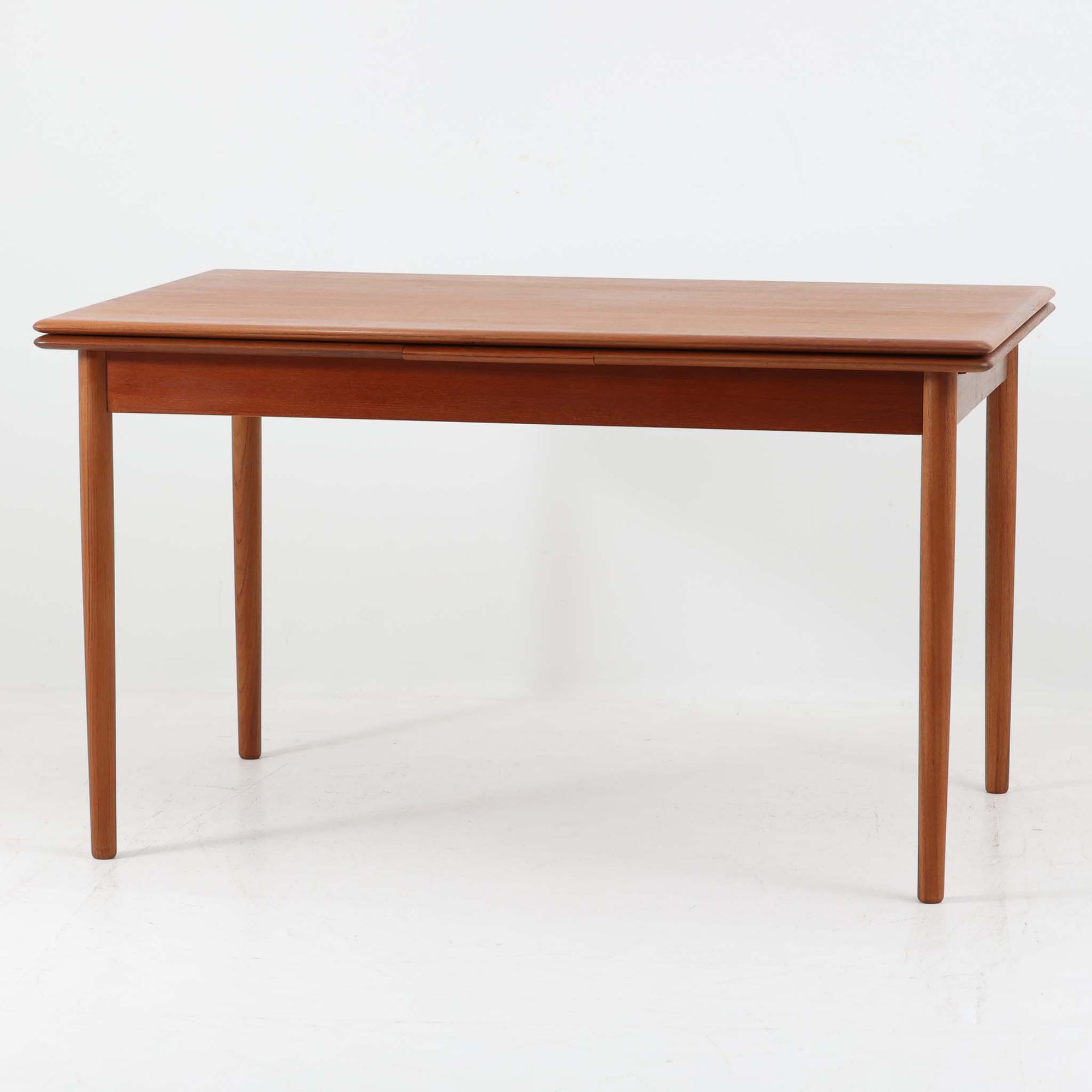 デンマーク製のエクステンションダイニングテーブルです。上質なチーク材が使用されており、木目の美しさと経年による深みのある色合いが魅力です。両サイドに拡張板を備え、幅128cmから最大231cmまで伸長可能で、シーンに応じて柔軟に対応できます。シンプルで端正なフォルムと細身の丸脚が軽やかな印象を与え、ダイニングの中心として存在感を放ちます。普段はコンパクトに、来客時にはゆったりと使える実用性に優れたビンテージ家具です。