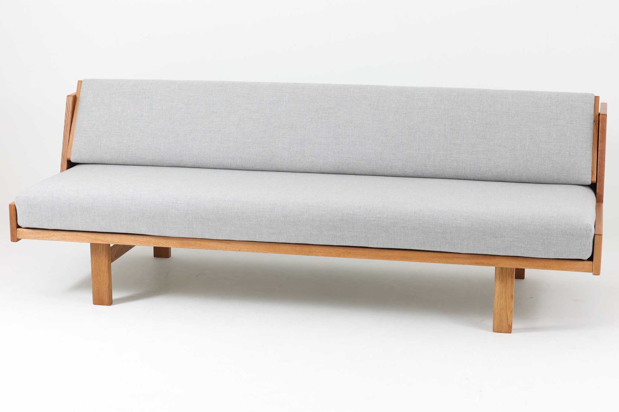 デンマークを代表する家具デザイナー、ハンス・J・ウェグナーによるデザインのデイベッド。シンプルで洗練されたフォルムと機能美が融合した、GATAmA社製の北欧ビンテージ家具です。フレームには経年により色味が濃くなったオーク材が使用され、優しい木の風合いが感じられる仕上がり。クッションは新しく張り替えており、快適な座り心地を提供します。背もたれ部分はスムーズに動かせる仕様で、簡単にデイベッドとして使用可能。リビングのソファとしてはもちろん、ゲスト用のベッドとしても活躍します。北欧デザインらしいミニマルで実用的な構造が特徴で、どんな空間にも馴染みやすい一台です。