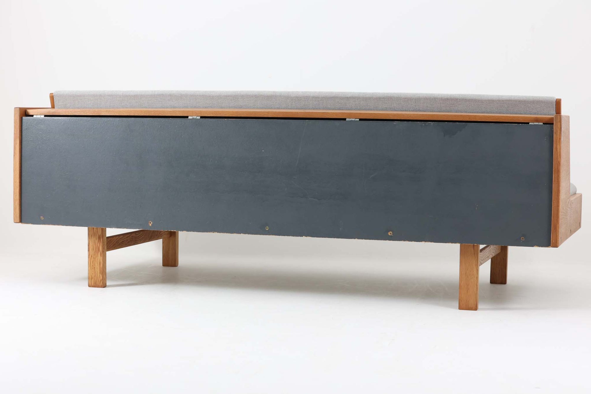 デンマークを代表する家具デザイナー、ハンス・J・ウェグナーによるデザインのデイベッド。シンプルで洗練されたフォルムと機能美が融合した、GATAmA社製の北欧ビンテージ家具です。フレームには経年により色味が濃くなったオーク材が使用され、優しい木の風合いが感じられる仕上がり。クッションは新しく張り替えており、快適な座り心地を提供します。背もたれ部分はスムーズに動かせる仕様で、簡単にデイベッドとして使用可能。リビングのソファとしてはもちろん、ゲスト用のベッドとしても活躍します。北欧デザインらしいミニマルで実用的な構造が特徴で、どんな空間にも馴染みやすい一台です。