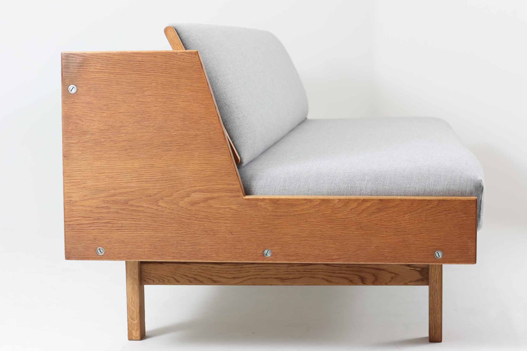 デンマークを代表する家具デザイナー、ハンス・J・ウェグナーによるデザインのデイベッド。シンプルで洗練されたフォルムと機能美が融合した、GATAmA社製の北欧ビンテージ家具です。フレームには経年により色味が濃くなったオーク材が使用され、優しい木の風合いが感じられる仕上がり。クッションは新しく張り替えており、快適な座り心地を提供します。背もたれ部分はスムーズに動かせる仕様で、簡単にデイベッドとして使用可能。リビングのソファとしてはもちろん、ゲスト用のベッドとしても活躍します。北欧デザインらしいミニマルで実用的な構造が特徴で、どんな空間にも馴染みやすい一台です。