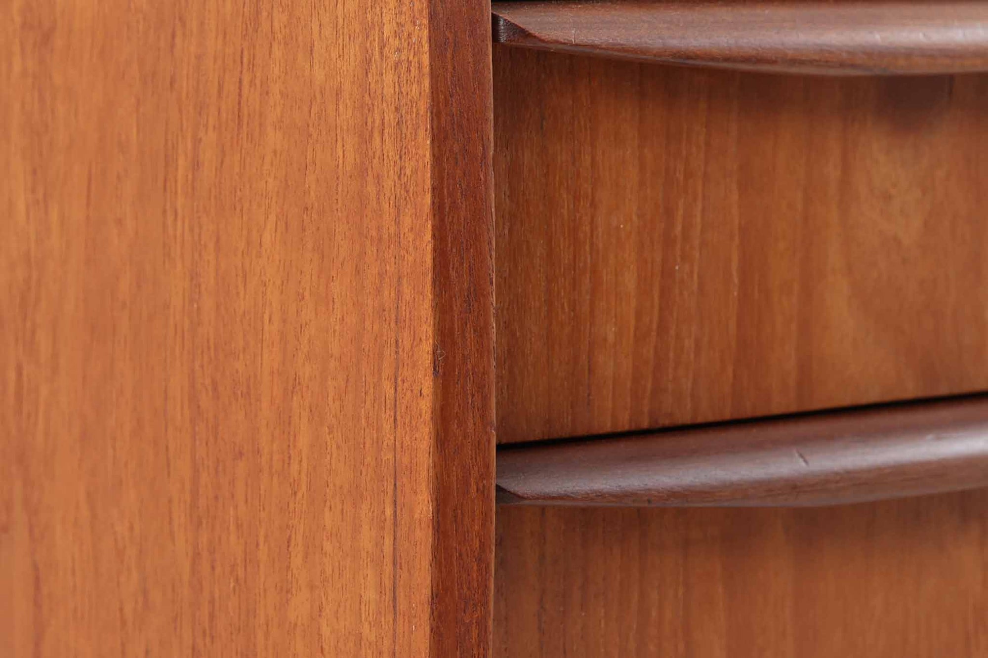 特徴的な丸みを帯びた側板と、典型的なデンマーク家具らしいバータイプの取手が素敵なデザインです。また、天板の両側面は物が落ちにくいように出っ張っており、実用性も考慮されています。本体には上質なチーク材が使用されています。使い勝手の良い小ぶりなサイズ感です。