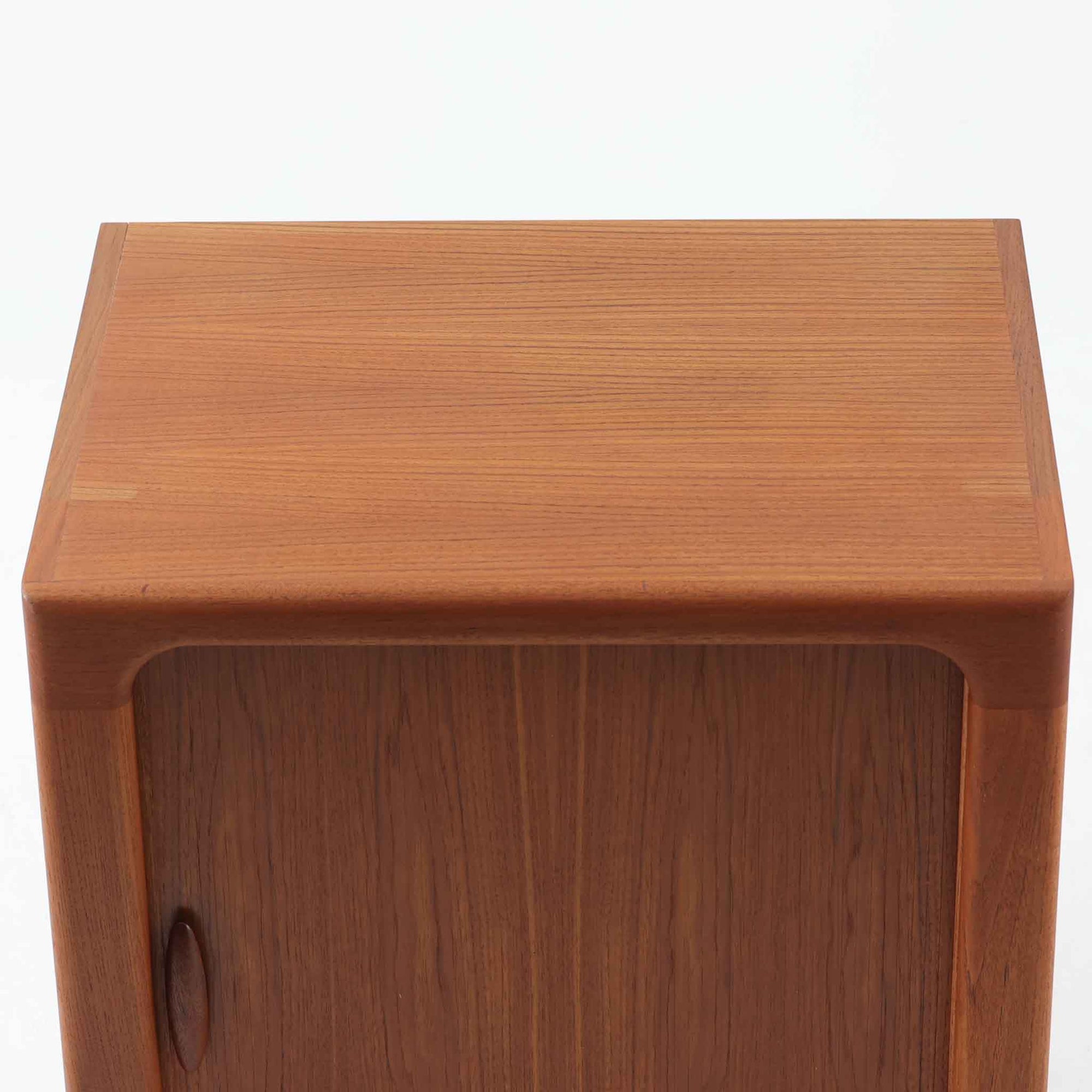 Dyrlund社製の蛇腹キャビネットは、美しいチーク材の木目と高度なクラフトマンシップが融合した北欧ビンテージ家具です。丸みを帯びたエッジや丁寧に加工された一体感のあるフレームが、柔らかな印象と上質さを漂わせます。最大の特徴である蛇腹式の扉は、細やかに組まれたチーク材のスラットがスムーズに開閉し、収納時にもデザイン性を損ないません。内部には実用的な棚が備わり、書類や小物類の整理に最適です。幅67cmとコンパクトながら、空間に豊かな存在感をもたらす一台です。使い込むほどに深まる色艶が、北欧ビンテージ家具ならではの魅力を際立たせています。