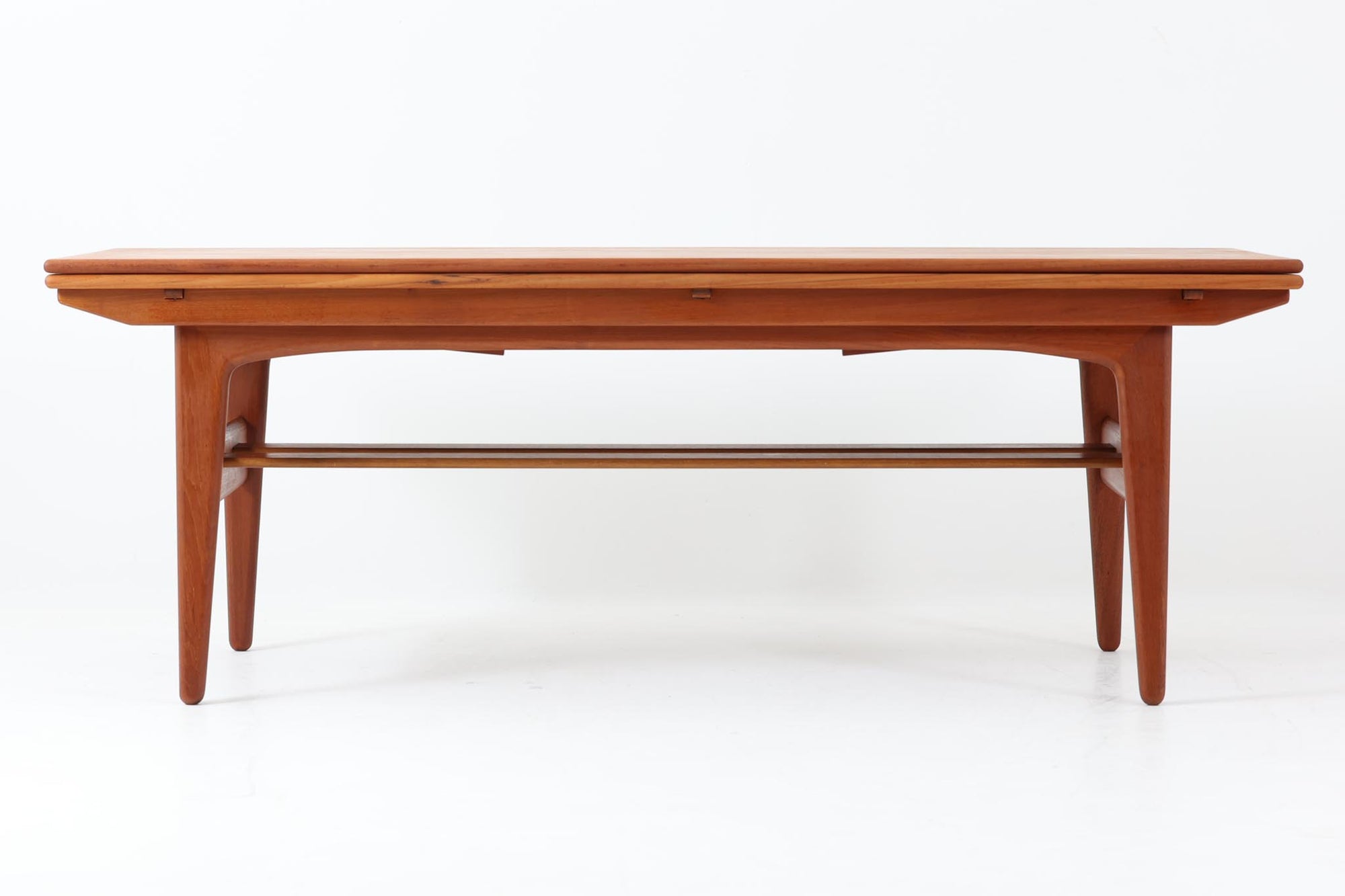 Kai Kristiansenデザインのエレベーターテーブルは、デンマークの名工Trioh moblerによって手作りされたシンプルで滑らかなデザインの逸品です。このテーブルは環境に応じて大きさを変えることができるため、デンマークではスタンダードアイテムとなっています。天板を片側だけ広げたり、高さを調整したりと、非常に機能的です。こちらは天板下に棚がある珍しいタイプです。1960年代にデザインされたものですが、丁寧にメンテナンスを行っているため長くお使いいただけます。