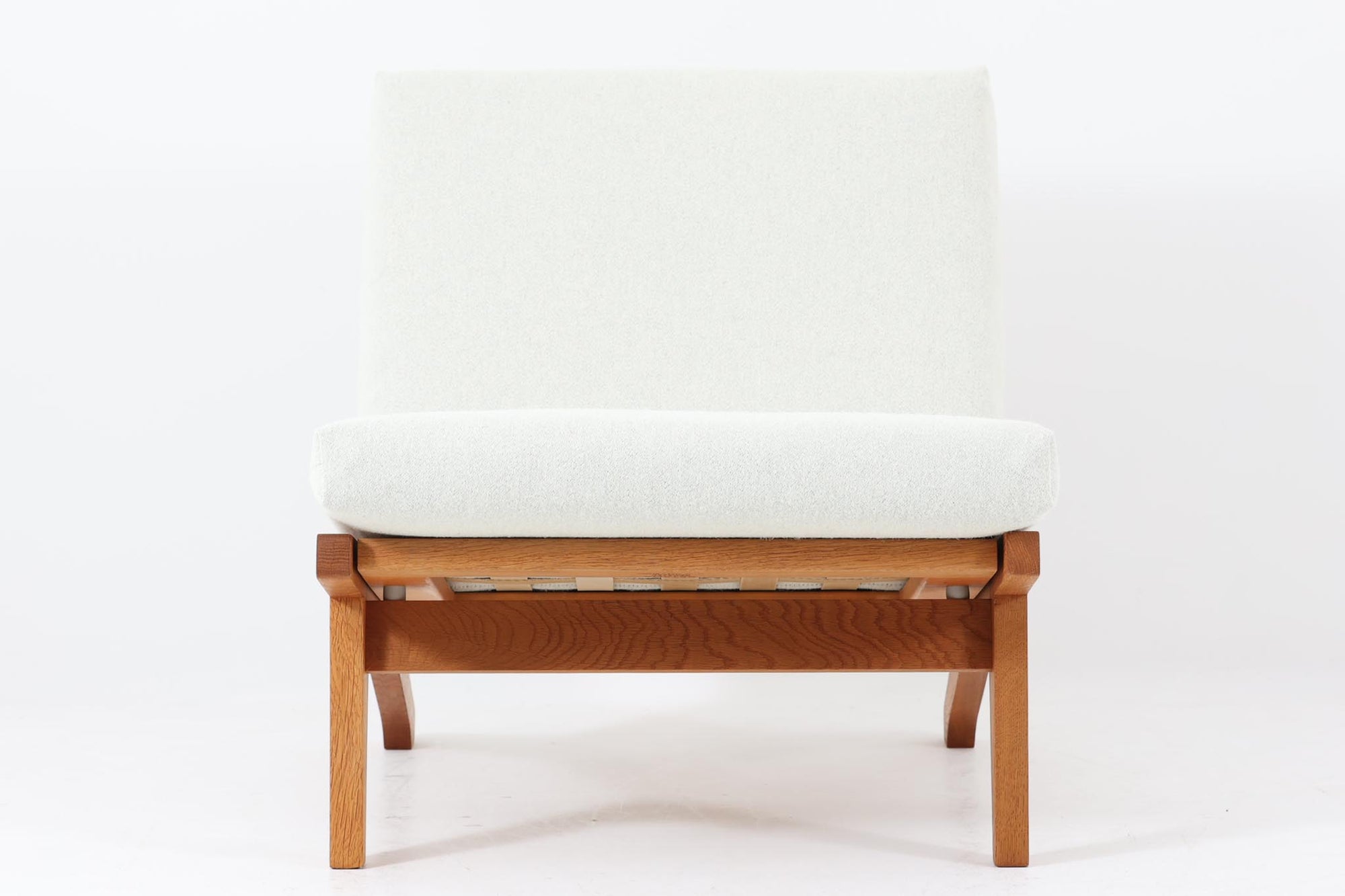 北欧より買い付けた「GE370」です。ウェグナーの作品の中でも、特筆すべきなのは、その柔軟性と機能性です。ソファを分解し、組み合わせることで、様々なレイアウトが可能です。例えば、別途アーム付きのGE370を購入すれば、それを連結して2人掛けソファとして使用することもできます。このソファも元々はアームを付けて使用されていたようで、そのため側面にアーム連結の色ヤケが見られます。本体には高品質なオーク材が使用されています。クッションはデンマーク製のデッドストック生地を使用して張替を行いました。デッドストック生地のため、若干の摩耗は見られますが綺麗な状態です。