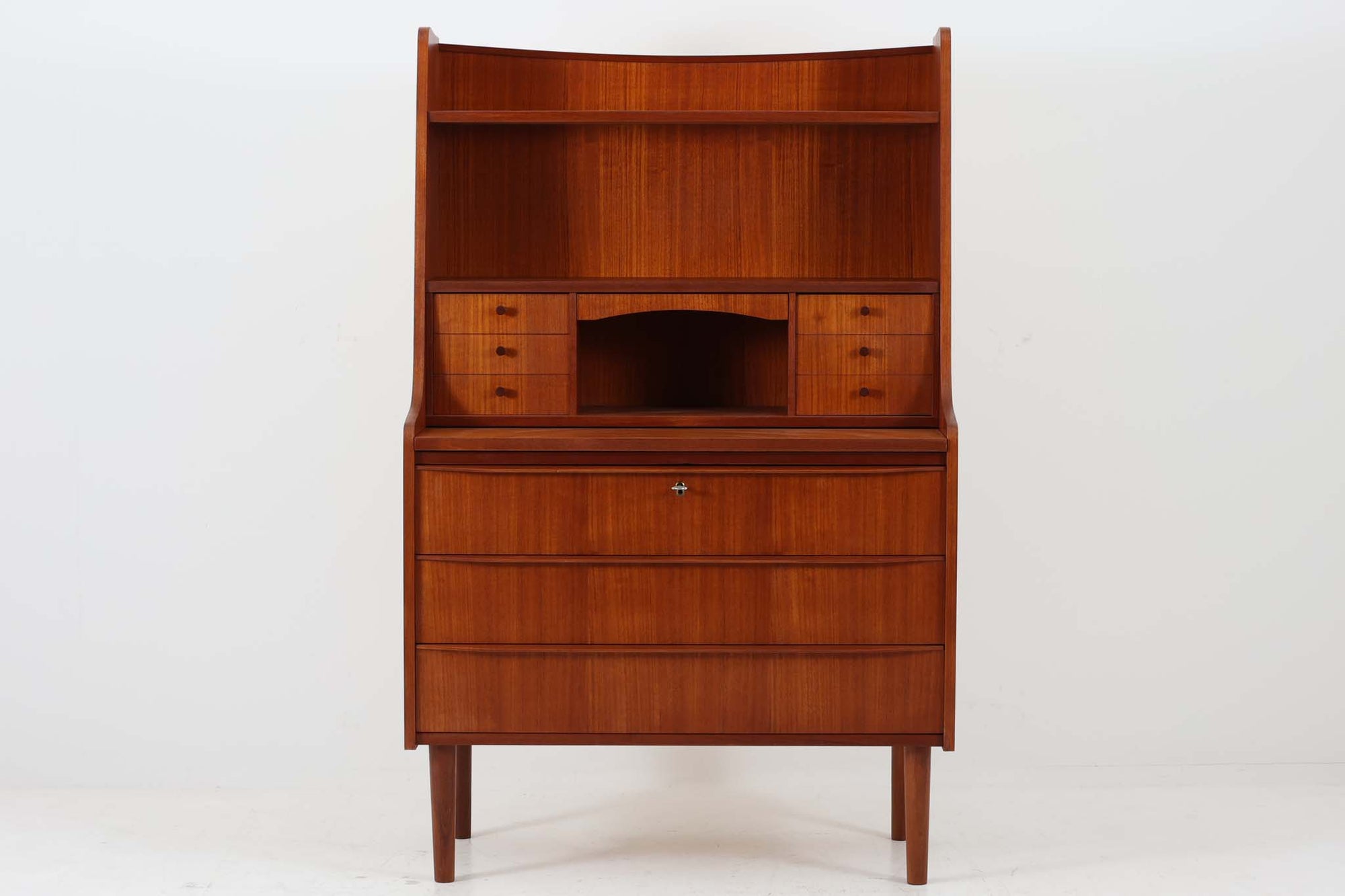 北欧より買い付けたライティングビューロです。高さがやや高めのため、デスクやチェスト、ドレッサーとしてはもちろん、シェルフとしてもお使いいただけます。小引き出しが6杯、大きな引き出しが3杯付いており、十分な収納力を備えています。良質なチーク材が使用されており、美しい色味が特徴です。インテリアとして飾り付けることで、また違った素敵な雰囲気を演出してくれる一品です。