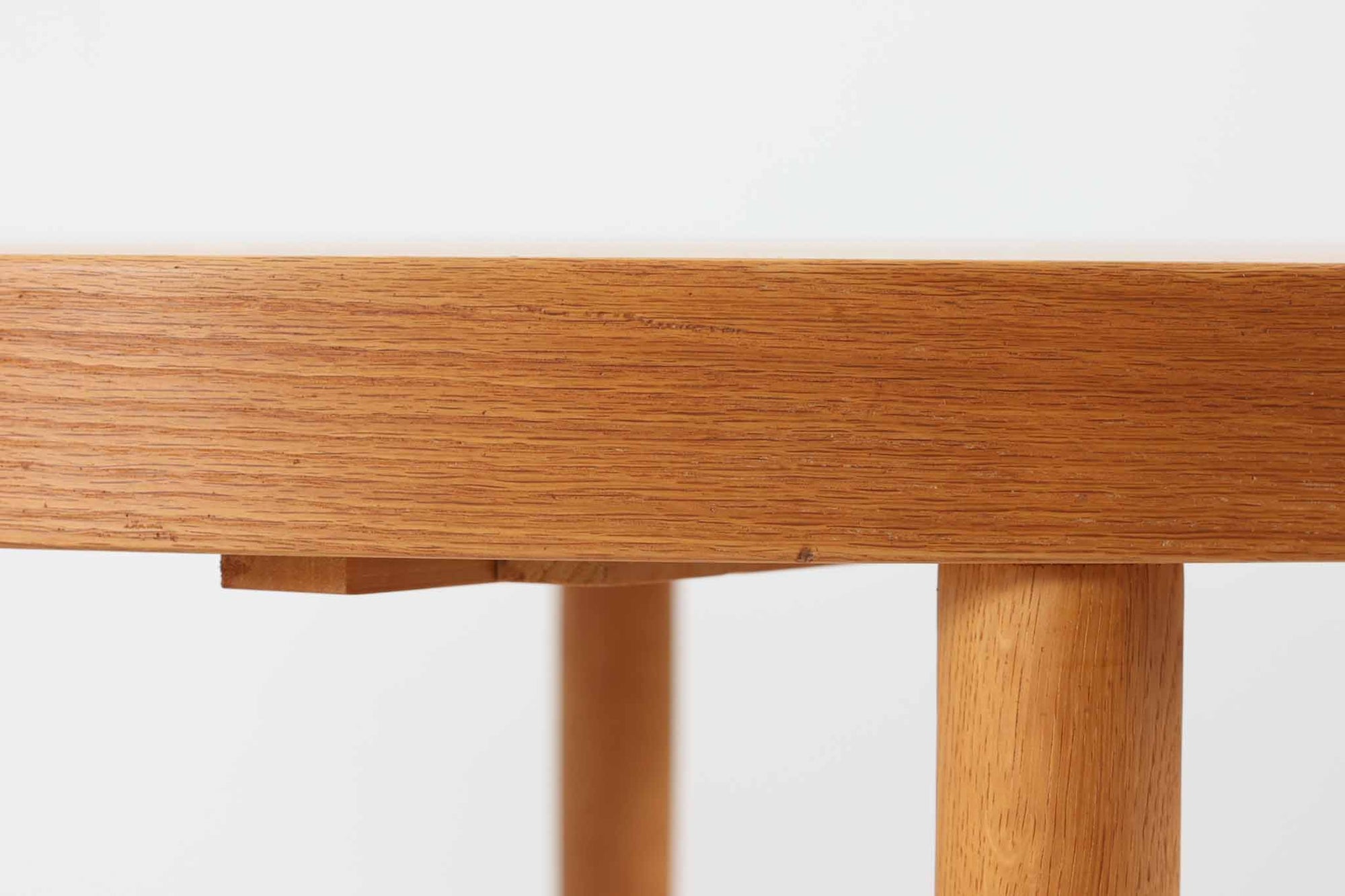 美しい木目のオーク材で作られたデンマーク製のビンテージダイニングテーブルです。シンプルでありながら北欧らしい洗練されたデザインが魅力で、エクステンション機能により天板を伸長して大人数にも対応可能です。天板を閉じた状態では直径のある円形テーブルとして、拡張時には楕円形になり広々とご使用いただけます。丸みを帯びた天板のエッジと先細りの脚が軽やかで、どんな空間にも調和します。Danish Controlの刻印も確認でき、品質の高さが伺える逸品です。北欧モダンな空間演出におすすめの一台です。