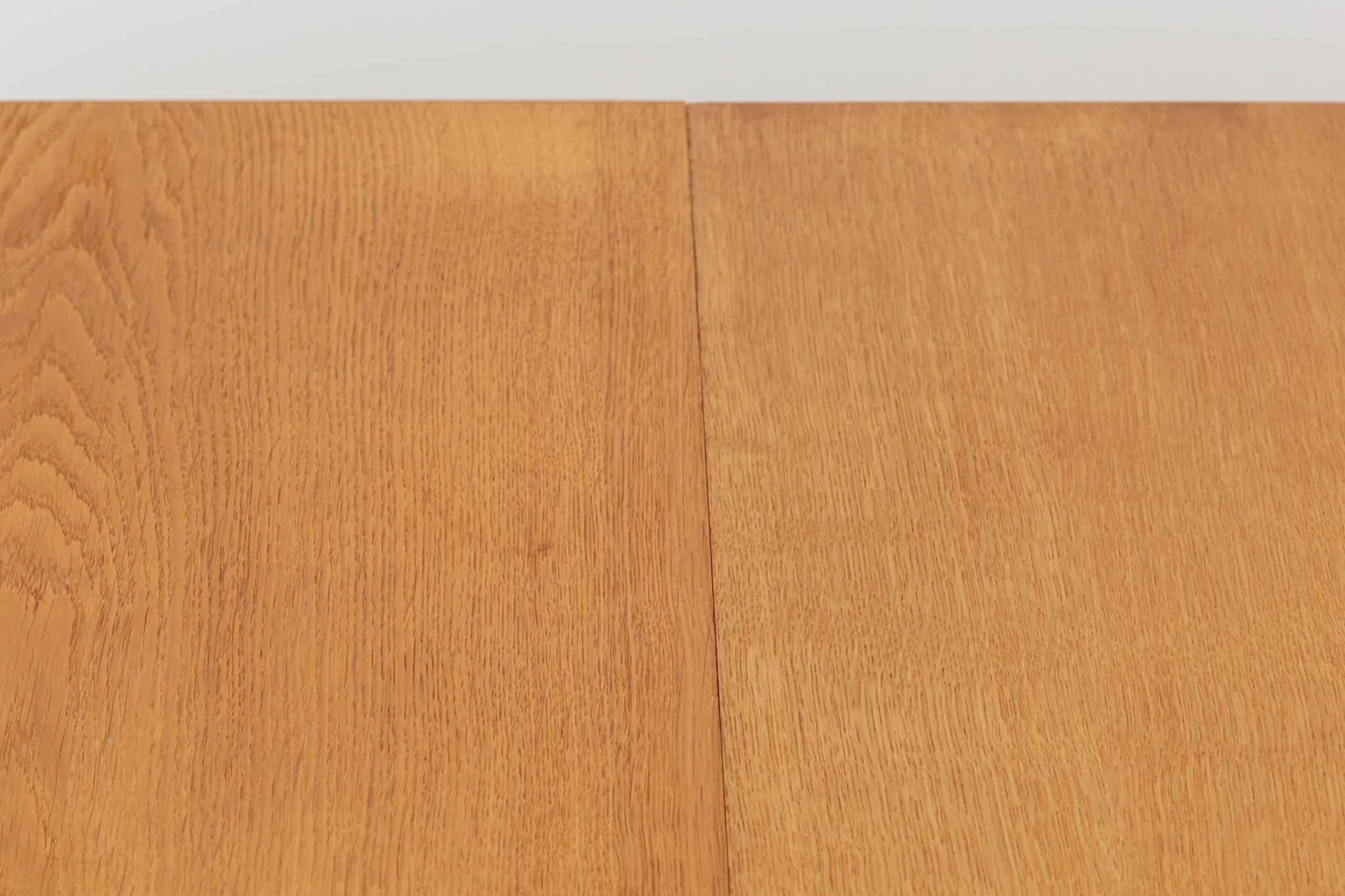 美しい木目のオーク材で作られたデンマーク製のビンテージダイニングテーブルです。シンプルでありながら北欧らしい洗練されたデザインが魅力で、エクステンション機能により天板を伸長して大人数にも対応可能です。天板を閉じた状態では直径のある円形テーブルとして、拡張時には楕円形になり広々とご使用いただけます。丸みを帯びた天板のエッジと先細りの脚が軽やかで、どんな空間にも調和します。Danish Controlの刻印も確認でき、品質の高さが伺える逸品です。北欧モダンな空間演出におすすめの一台です。