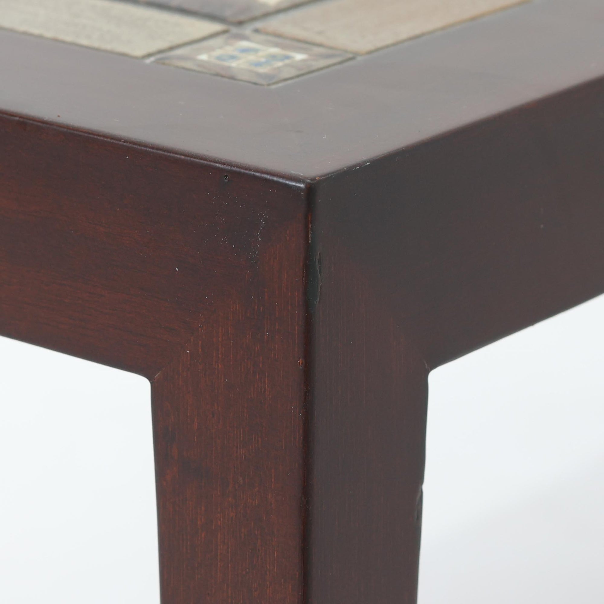 Nils Thorssonがデザインを手掛け、Royal CopenhagenのBACAシリーズのタイルを天板に配したセンターテーブルです。家具メーカーHaslev社により製作され、マホガニー材の落ち着いた木目と、幾何学的で温かみのあるタイル意匠が美しく調和しています。直線的で端正なフォルムは空間をすっきりと見せ、リビングの主役としてはもちろん、ソファ前のローテーブルとしても活躍。経年により深みを増した木部と味わい豊かな陶板が、北欧ビンテージならではの存在感を放つ一品です。