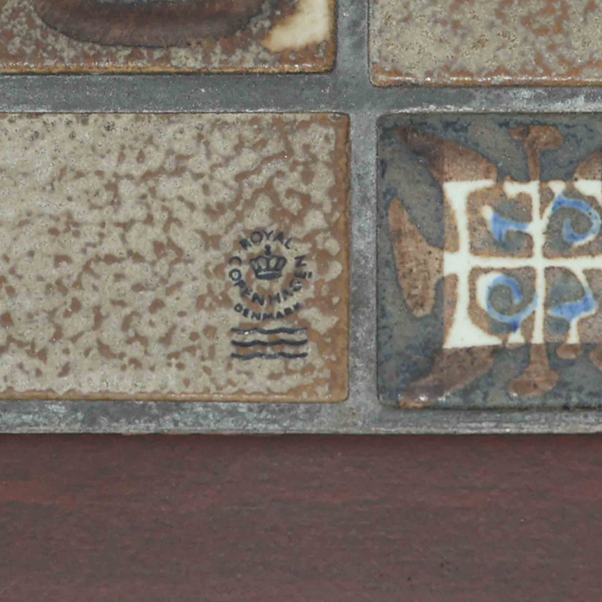 Nils Thorssonがデザインを手掛け、Royal CopenhagenのBACAシリーズのタイルを天板に配したセンターテーブルです。家具メーカーHaslev社により製作され、マホガニー材の落ち着いた木目と、幾何学的で温かみのあるタイル意匠が美しく調和しています。直線的で端正なフォルムは空間をすっきりと見せ、リビングの主役としてはもちろん、ソファ前のローテーブルとしても活躍。経年により深みを増した木部と味わい豊かな陶板が、北欧ビンテージならではの存在感を放つ一品です。