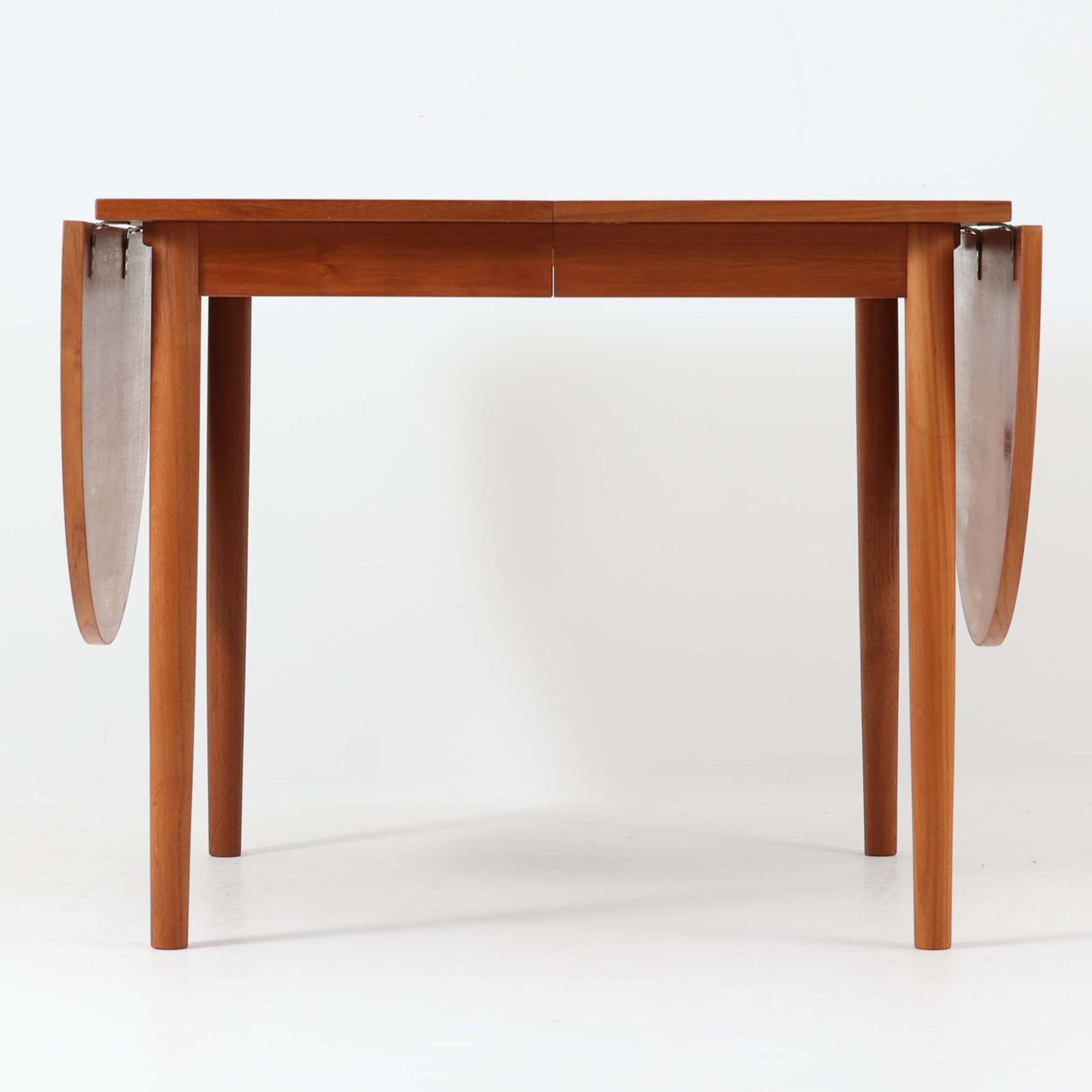 深みのある色合いと美しい木目が魅力のチーク材を使用したエクステンションテーブルは、北欧ビンテージ家具らしい温もりと上質さを感じさせてくれます。バタフライ式の両側天板は必要に応じて展開でき、使わない時はコンパクトにたたんで省スペースに、来客時にはしっかり広げて対応できる、利便性に優れた一台。シンプルながらも洗練された佇まいは、日常使いから特別なシーンまで幅広く活躍します。中央の拡張板が欠品していることと、脚部に割れの修理跡が見受けられるため、それらの点を考慮し価格に反映しております。