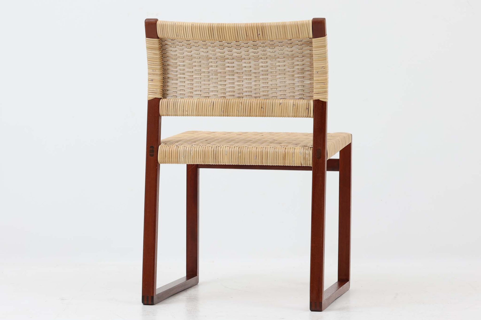 北欧より買い付けた「Bm61」です。このチェアは、脚先がつながったデザインとなっており、フローリングはもちろん、畳にダメージを与えにくいため、畳の部屋でもご使用いただけます。そのため、日本の家庭でも使い易いチェアです。軽量ながらも強度があり、背もたれがくの字になっており、ラタンの柔軟な強度も相まって座り心地も良好です。ラタンはデンマーク国内の家具張り替え専門店「Bruun Olsen Flet」で一度張り替えられており、前オーナーが長く丁寧に使用していたことがうかがえます。日本に入荷した際にはラタンが弱っていたため、日本の北欧家具椅子張り専門の職人によって再度張替を行いましたので、今後も長くご使用いただけます。このチェアは2020年にFredericiaよりオーク材のモデルが復刻されましたが、マホガニー材のものはビンテージ品でのみ入手可能です。